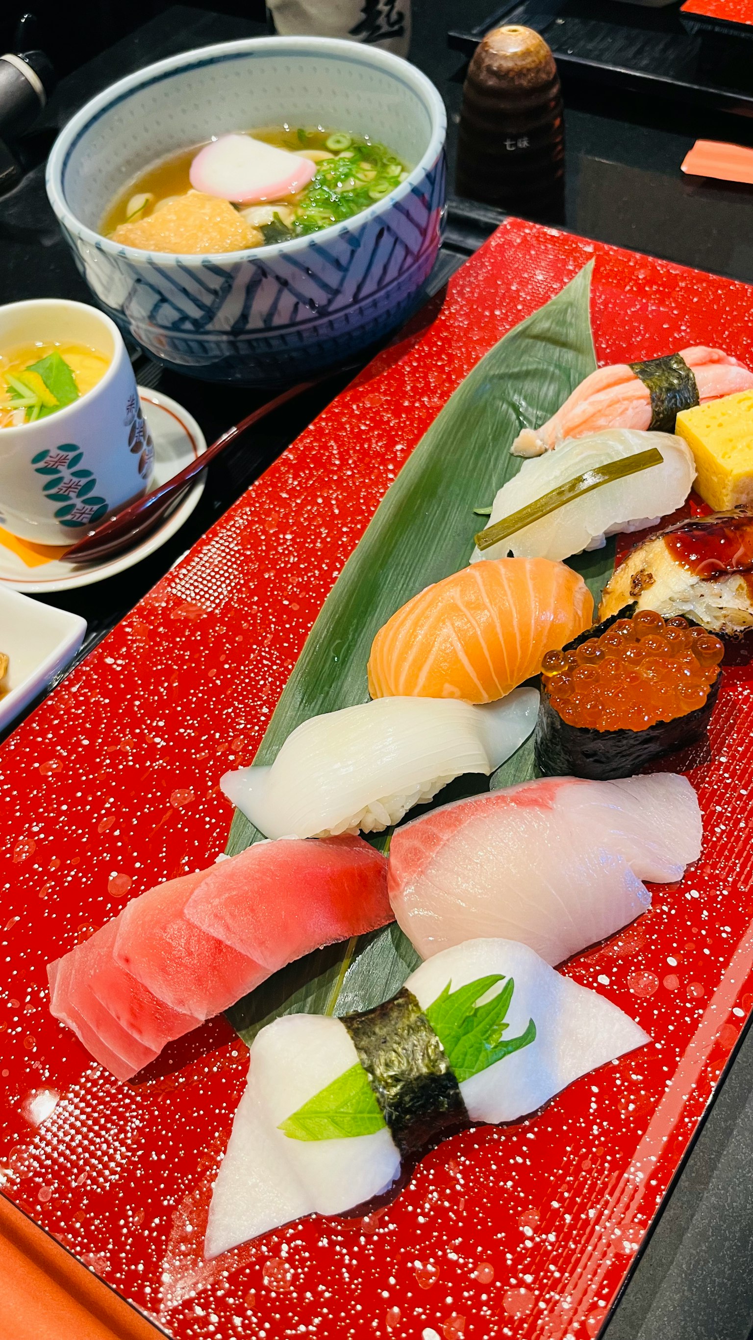 Sushi colorato splendidamente disposto su un piatto con zuppa di miso