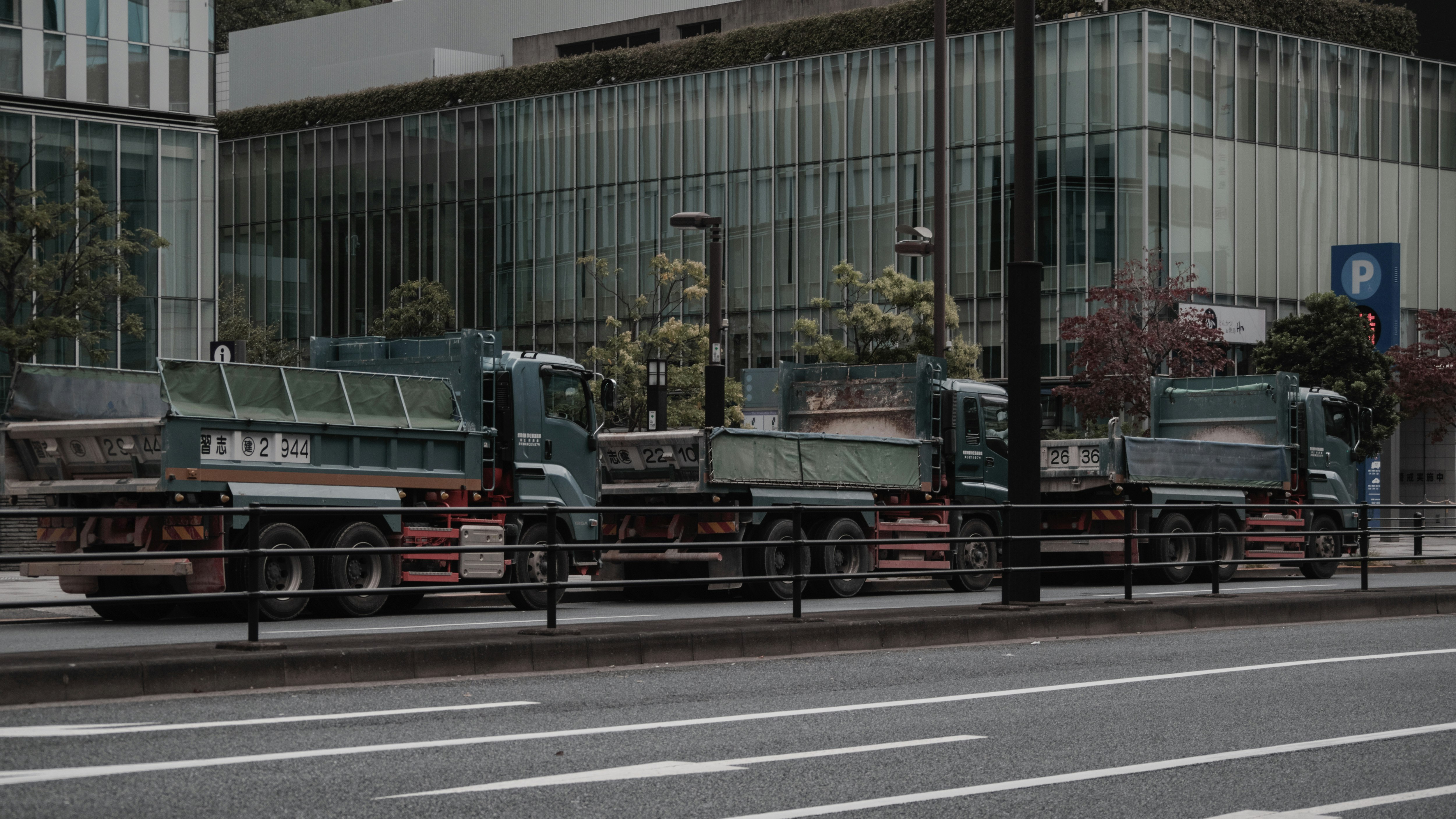 A line of trucks driving along a city road