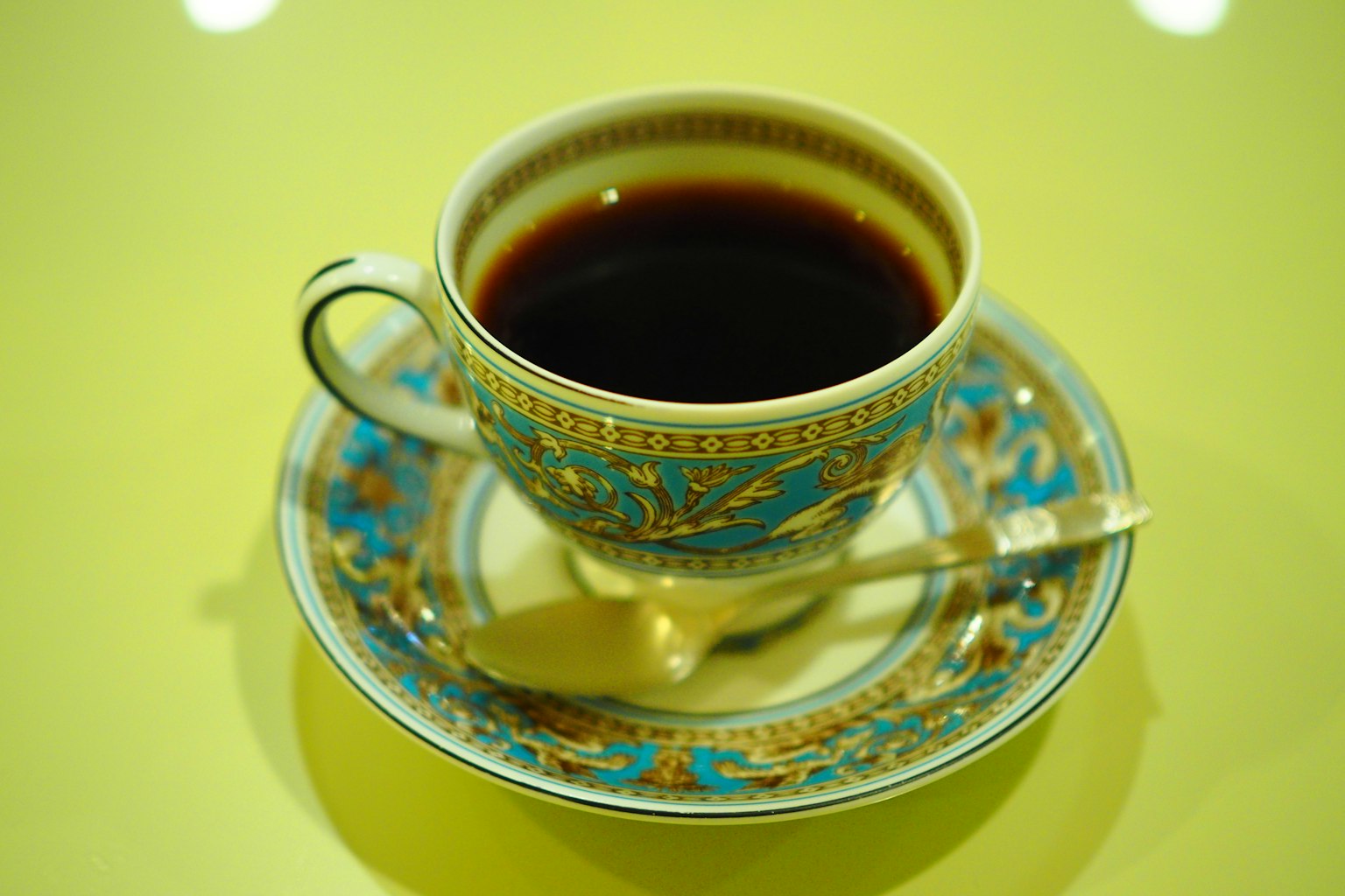 裝飾有藍色圖案的杯子裡盛著黑咖啡