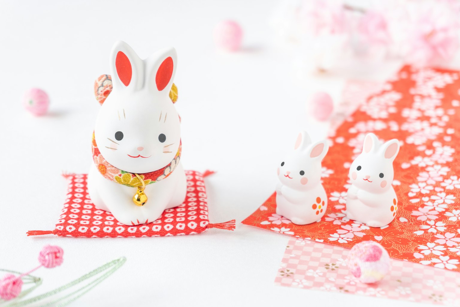 Figurines de lapin blanches sur un tissu rouge à motifs floraux