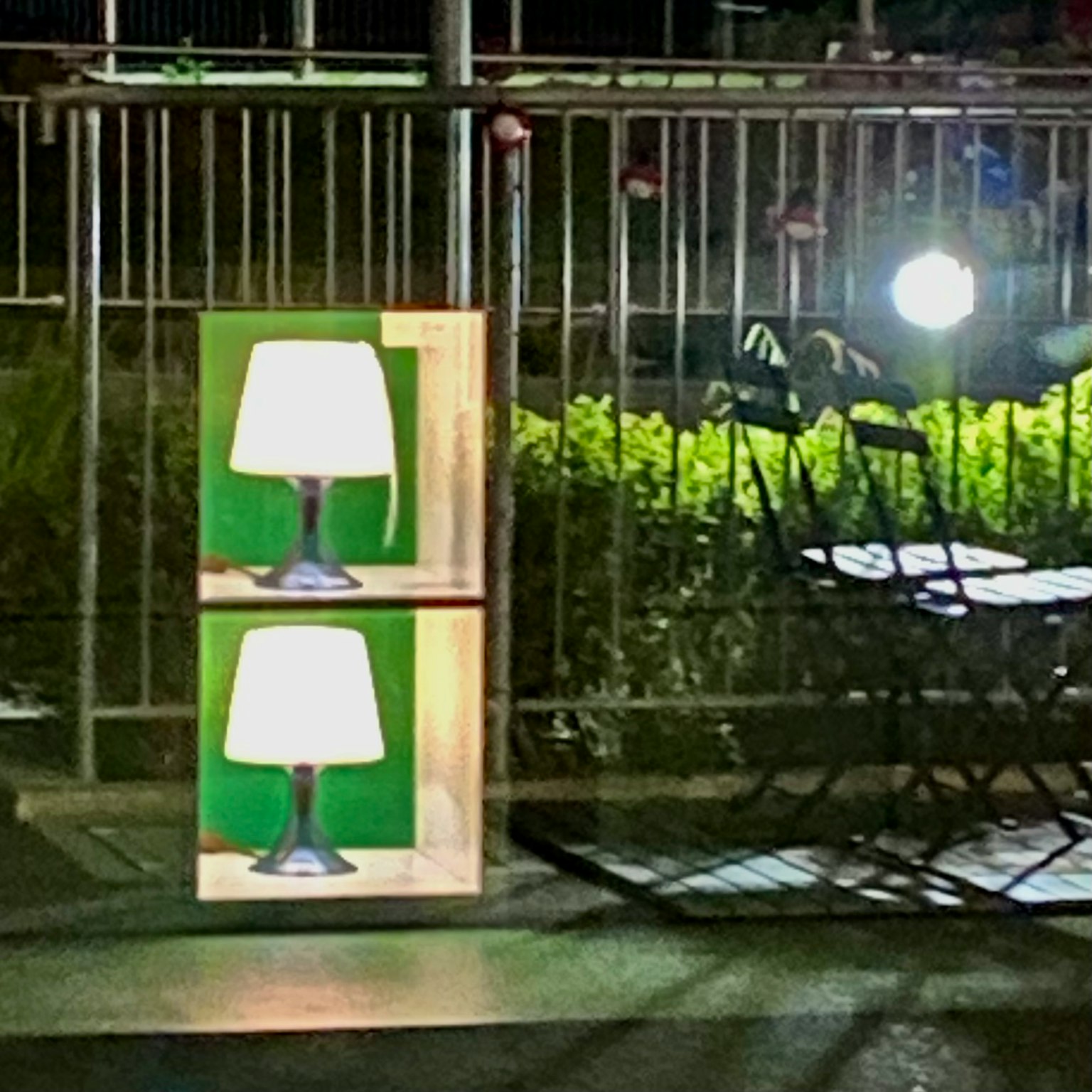 Holzkiste mit zwei Lampen vor grünem Hintergrund in der Nacht