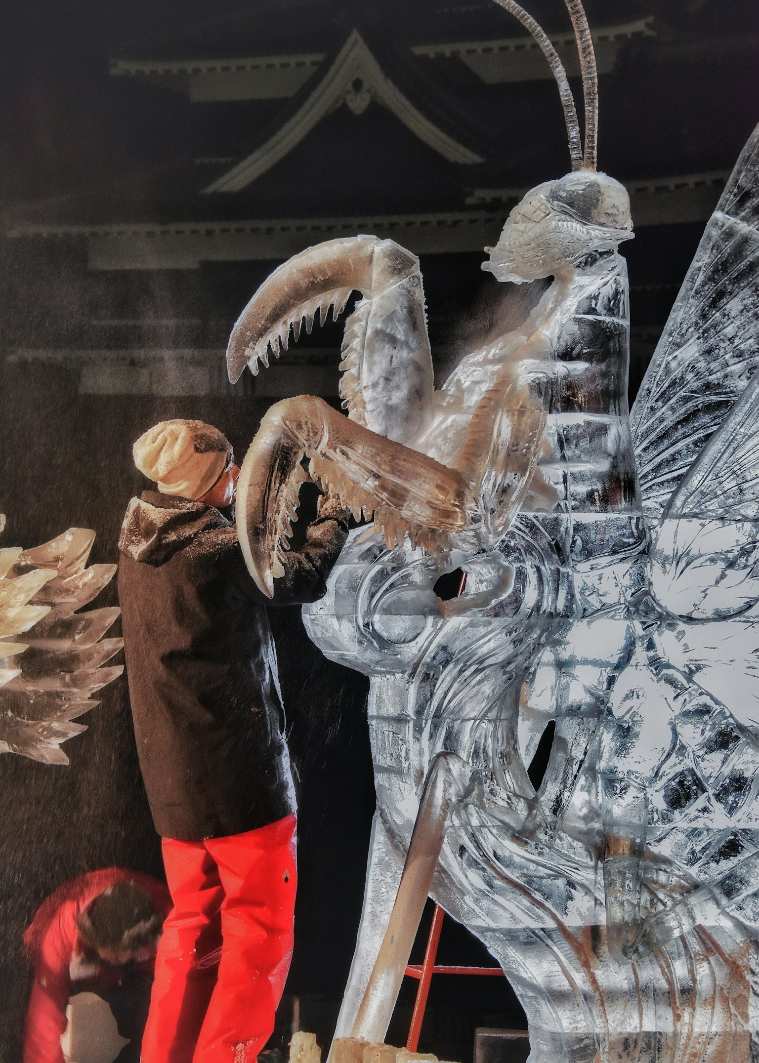 Künstler, der eine Eisskulptur mit komplexen Details schnitzt