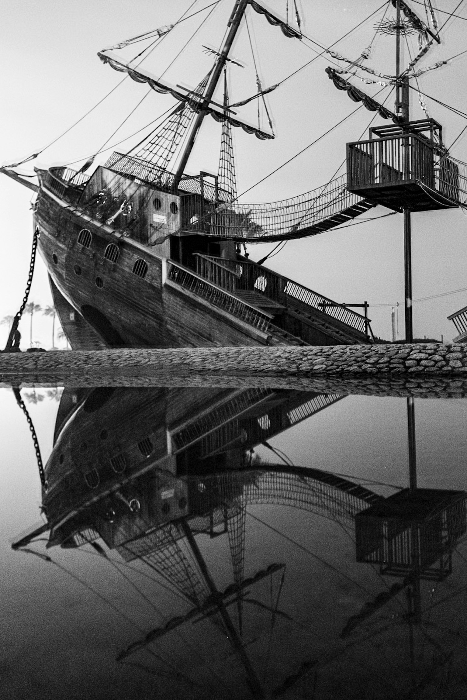 Un bateau en noir et blanc se reflétant sur la surface de l'eau
