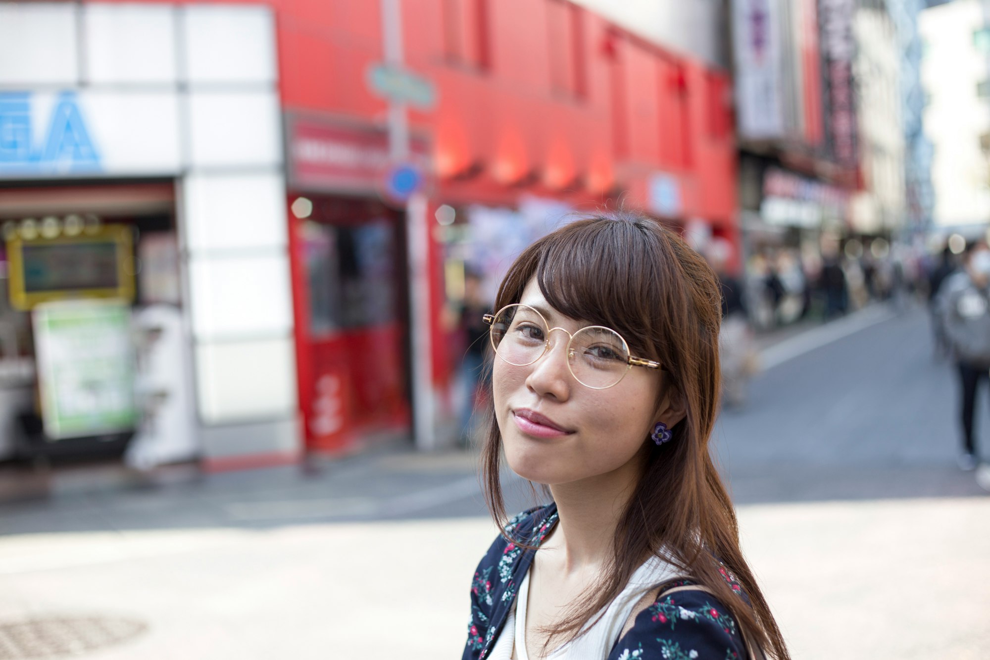 戴眼鏡的女性在城市街道上回頭看