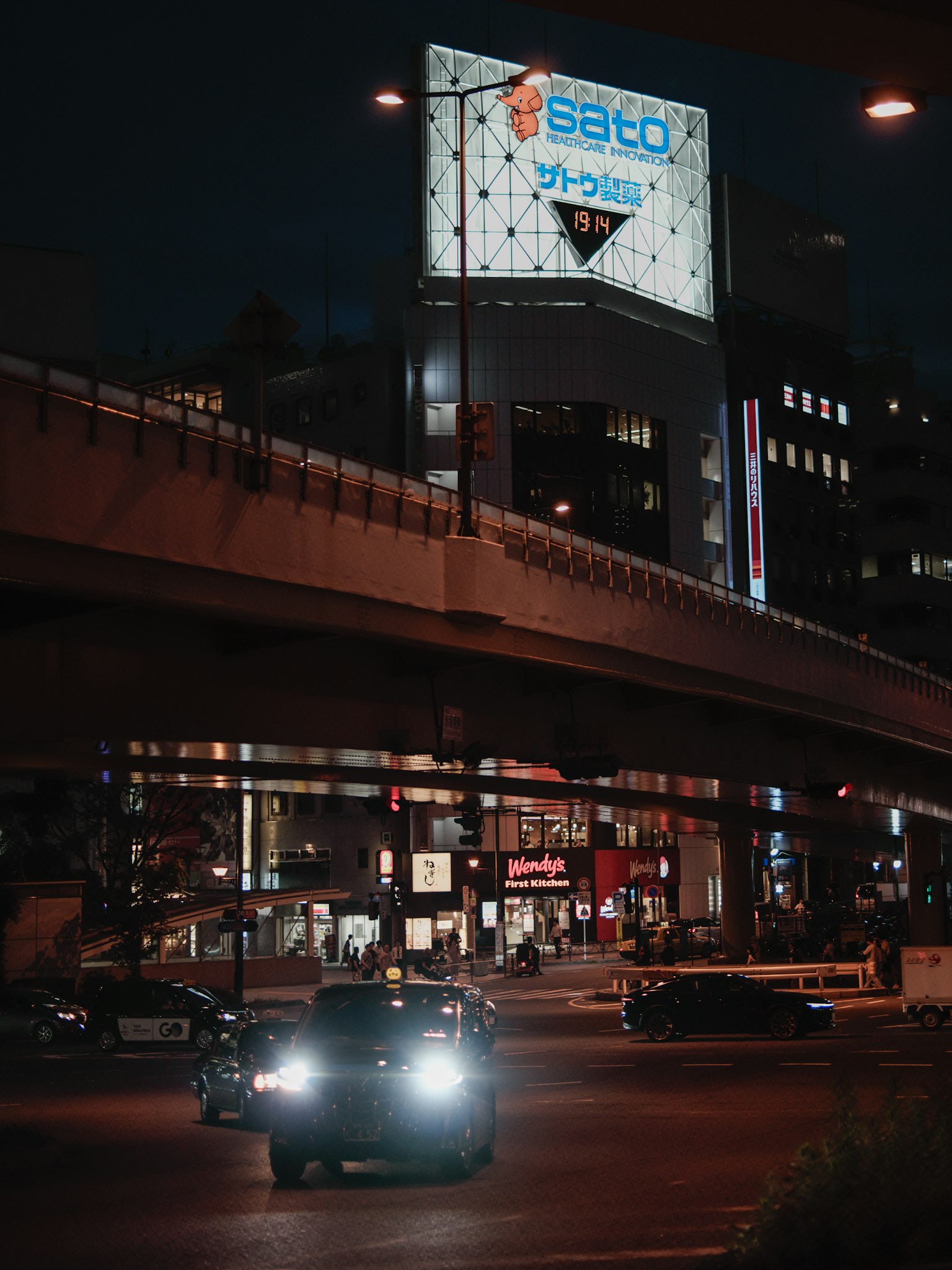 夜間城市景觀，照亮的汽車和廣告牌