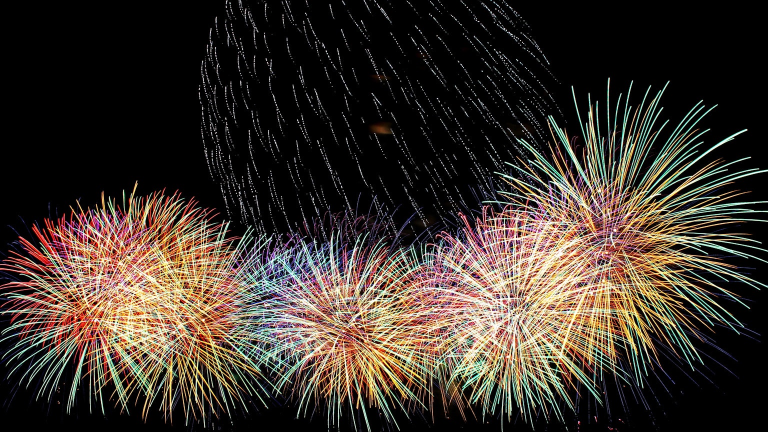 Fuegos artificiales coloridos estallando en el cielo nocturno