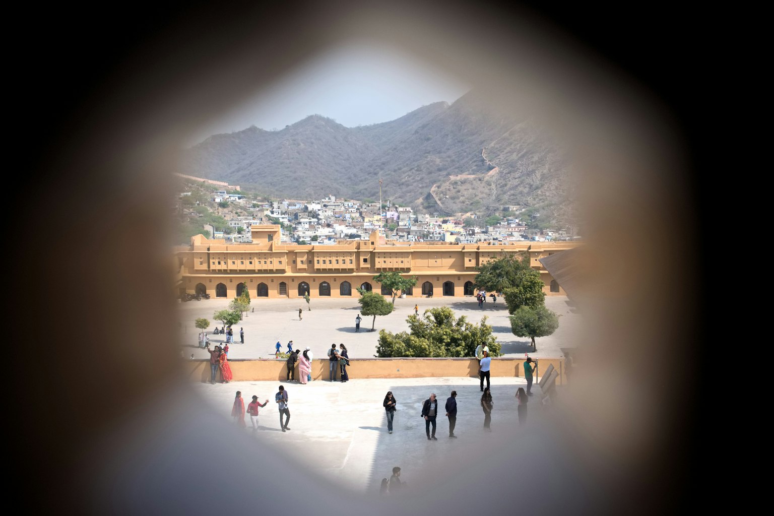 透過圓形開口看到的歷史建築，背景是山脈
