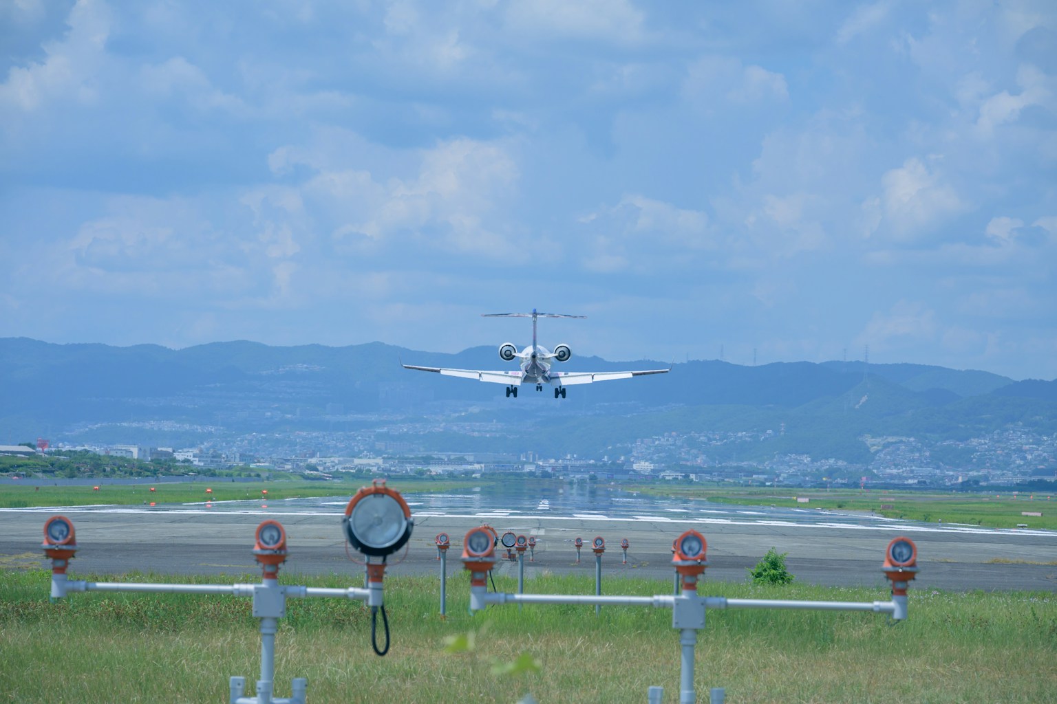 Kleinflugzeug landet auf der Landebahn mit umliegender Landschaft