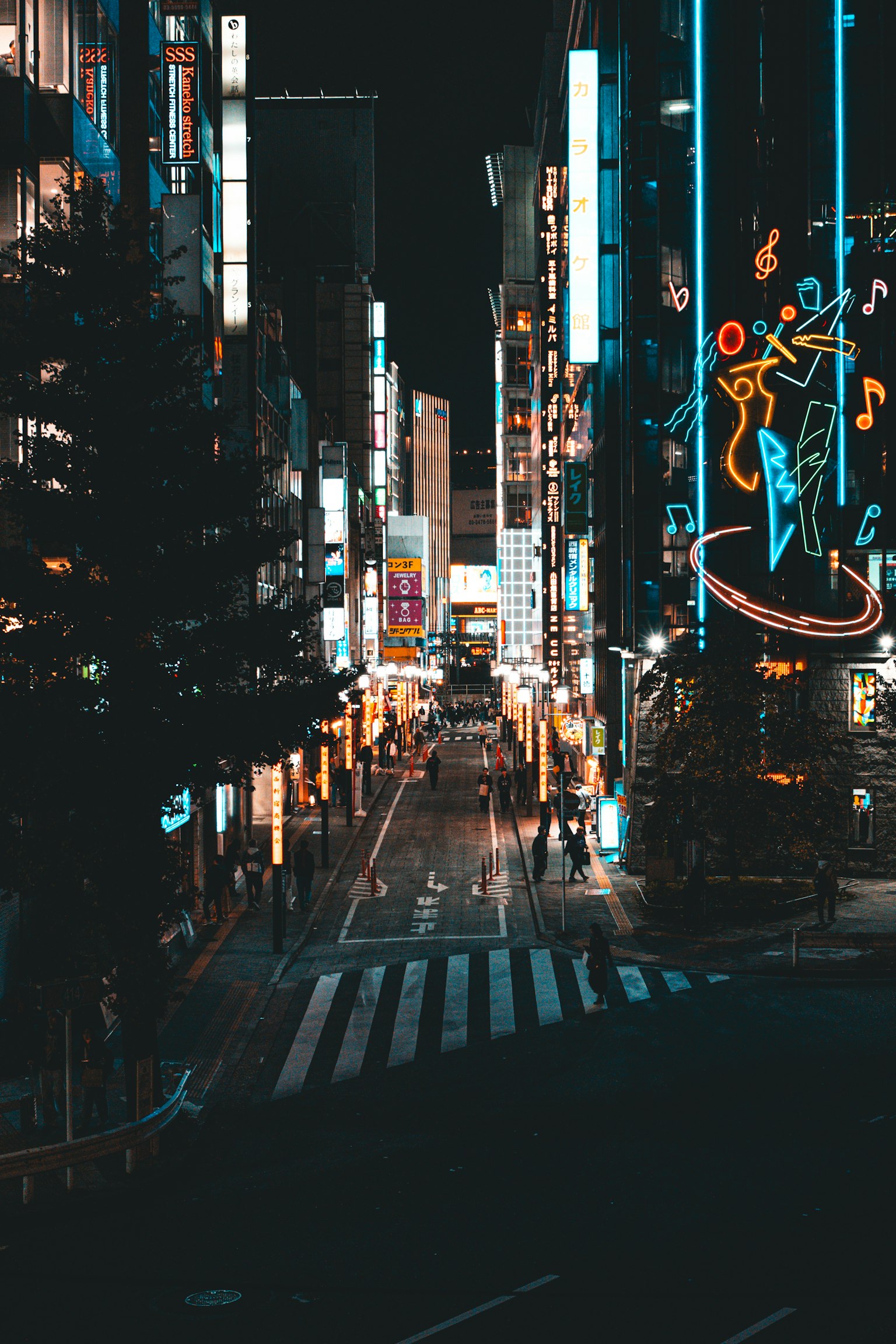 Rue animée la nuit avec des lumières au néon et des piétons