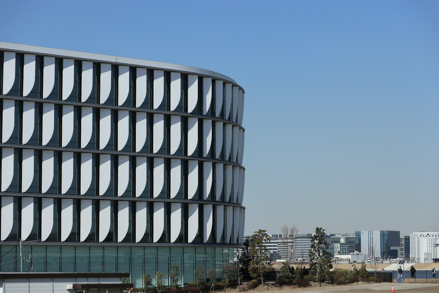 Fachada de un edificio moderno con un diseño curvo único y cielo azul claro