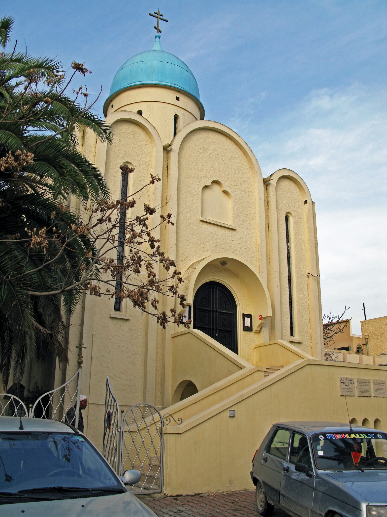 Eksterior gereja kuning dengan kubah biru dan tangga