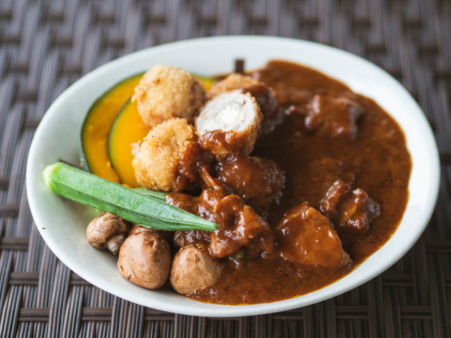 A plate of curry-flavored dish with assorted vegetables
