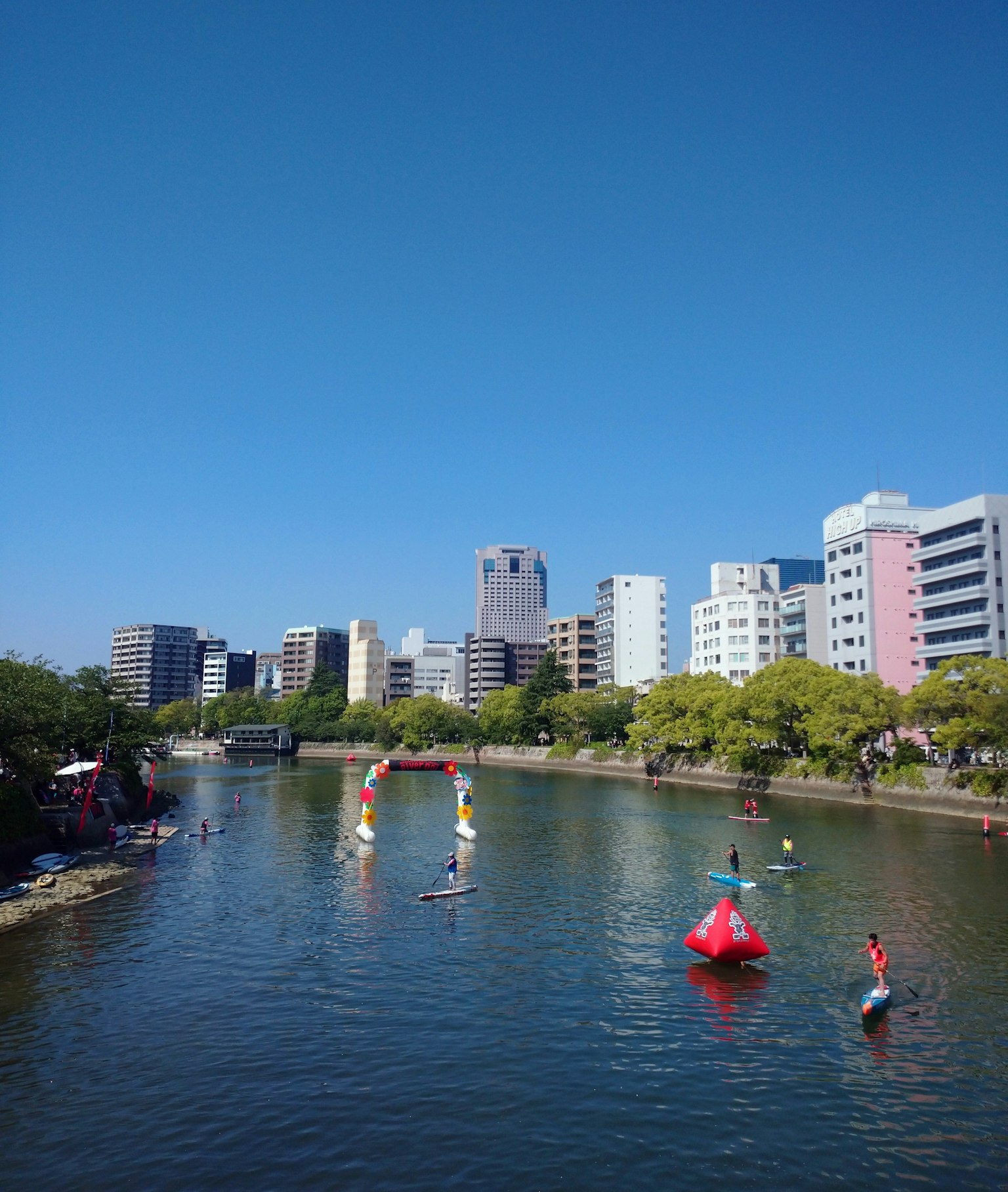 人们在河上享受活动，背景是现代建筑