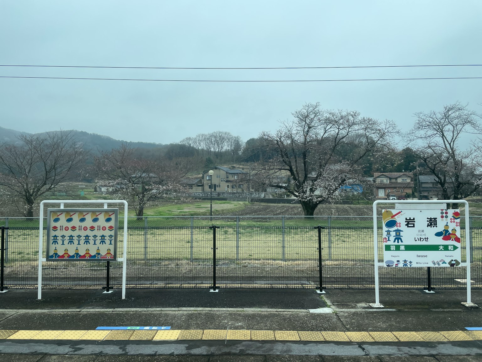 Vista de un día nublado desde una plataforma de tren con señales informativas