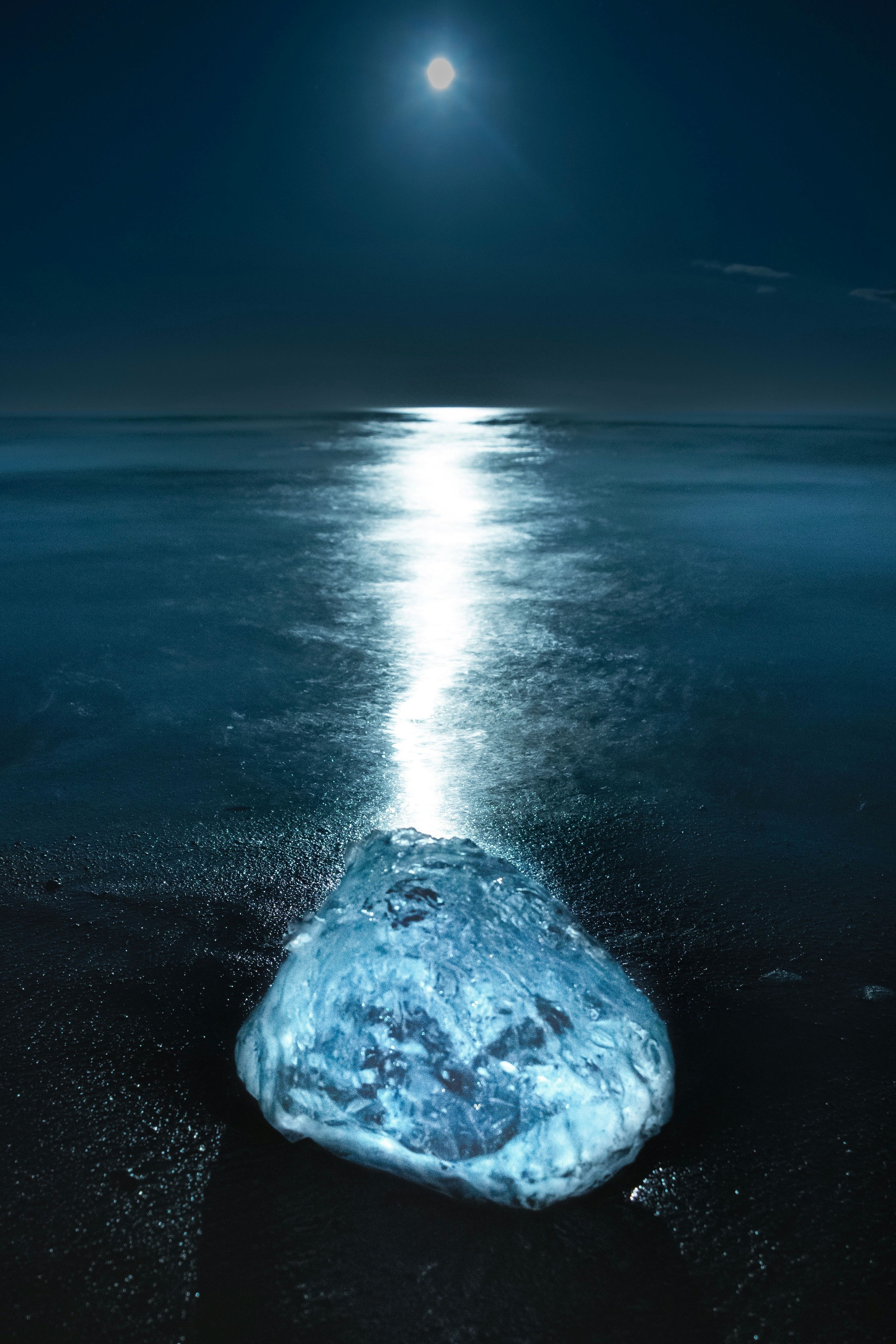 pantai berbulan di malam hari dengan es seperti permata