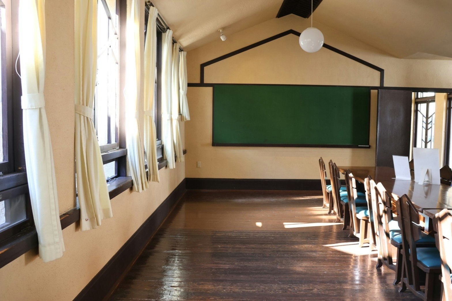 pasillo tipo aula con cortinas y bancos largos