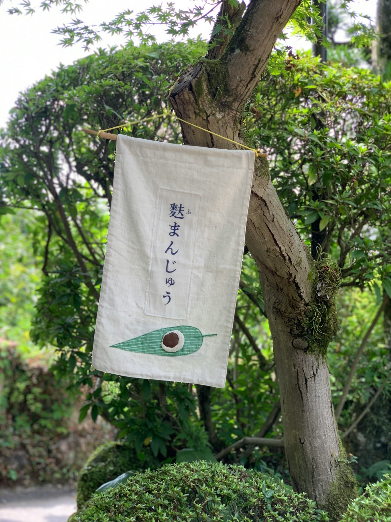 懸掛在樹上的日本旗幟，設計有綠色葉子