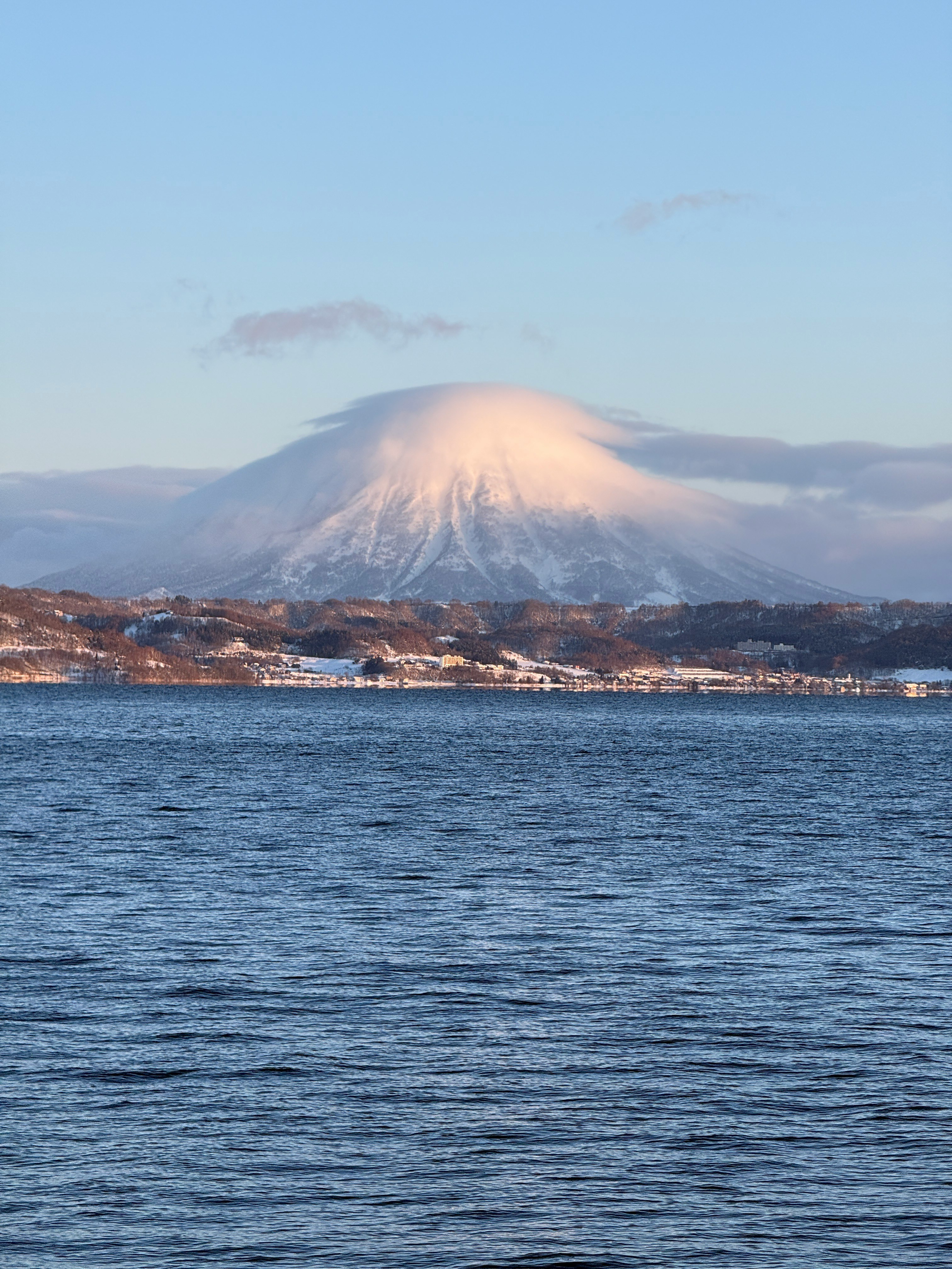 雪をかぶった山と穏やかな水面の風景