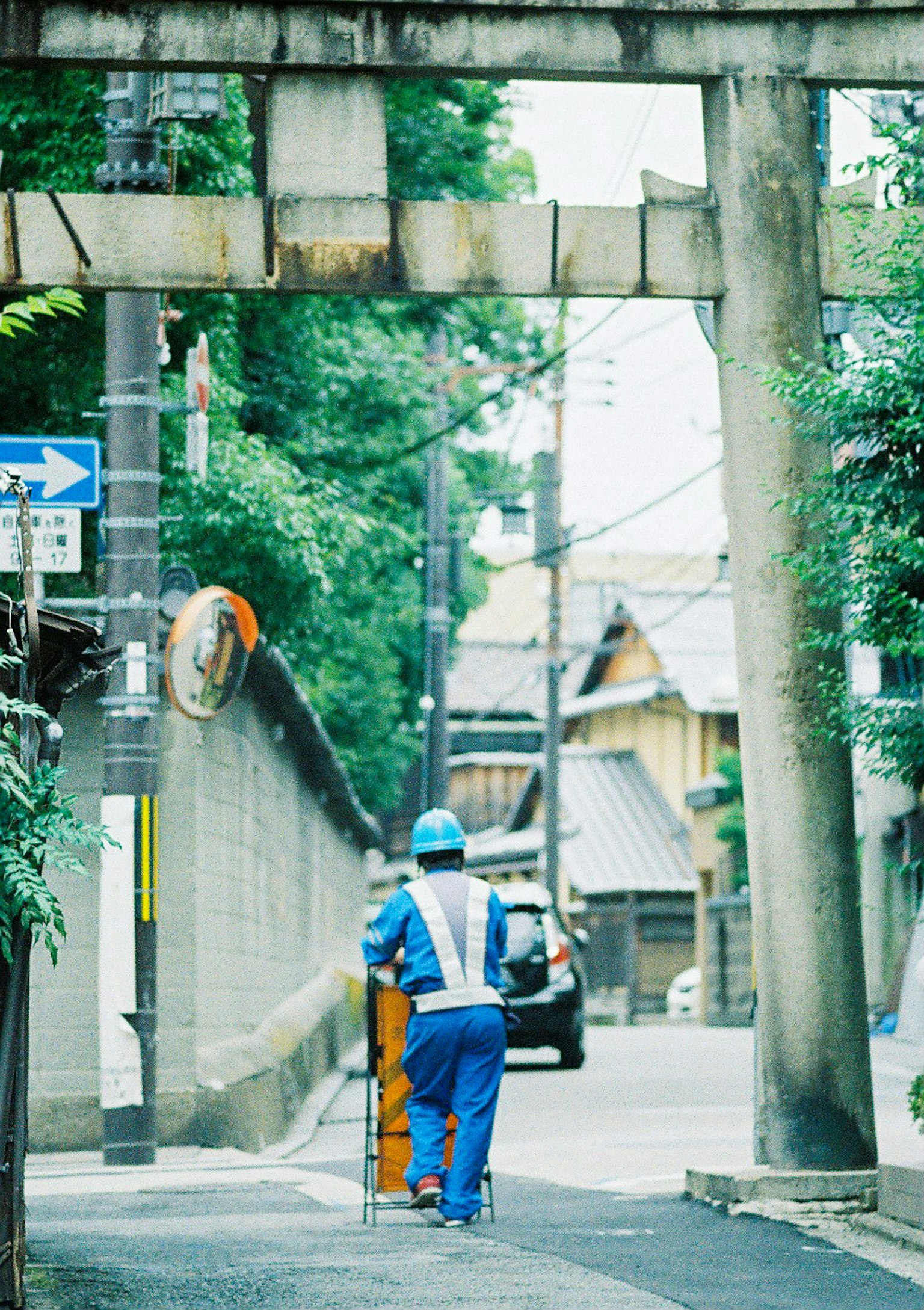 A worker in a blue uniform walking down a street