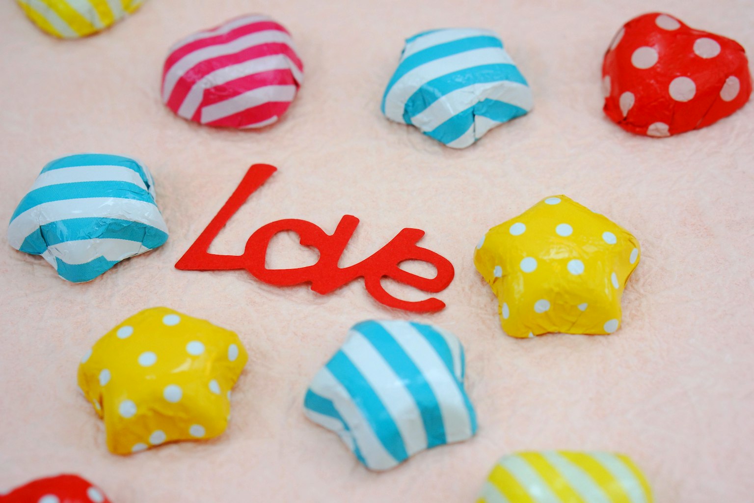 Caramelos en forma de estrella coloridos con texto rojo que dice Love