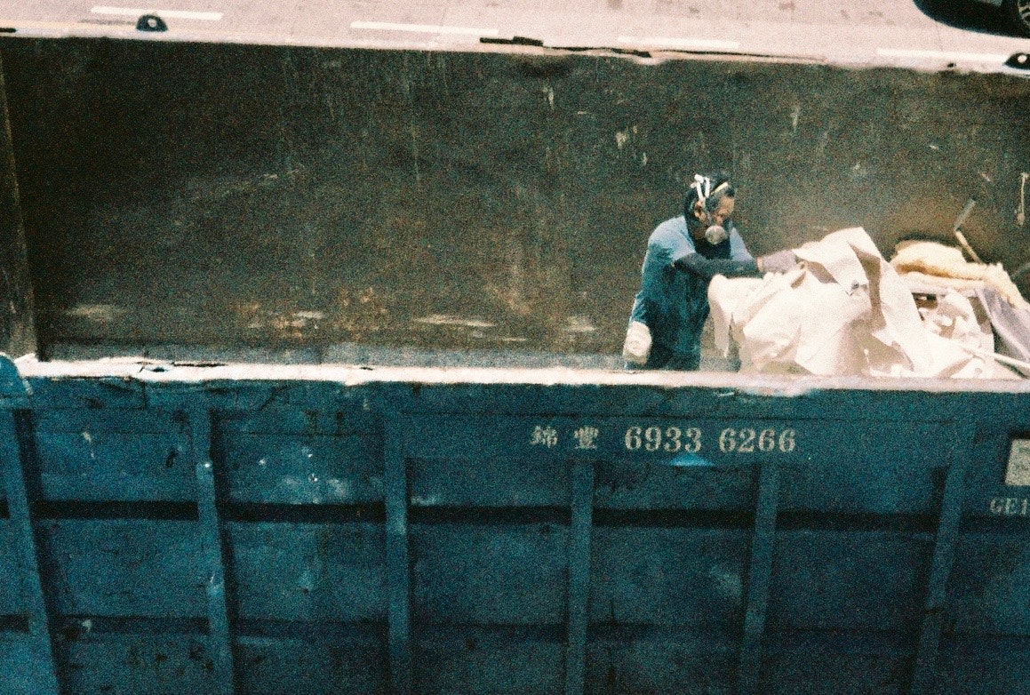 trabajador y sacos apilados frente a un muro azul