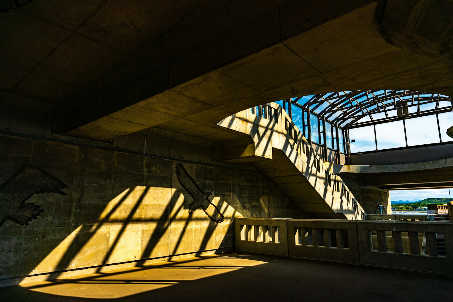 Interior view of a modern building with bright light and shadow patterns on the staircase