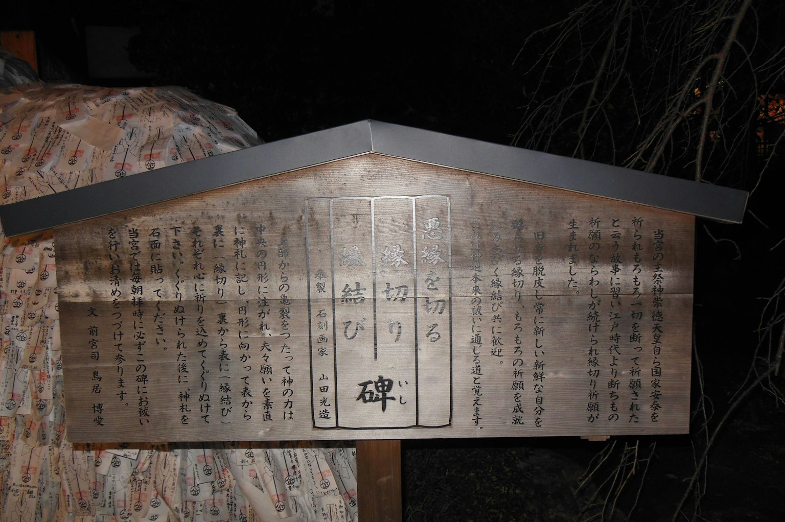 夜晚矗立的木製標牌，上面有日文文字
