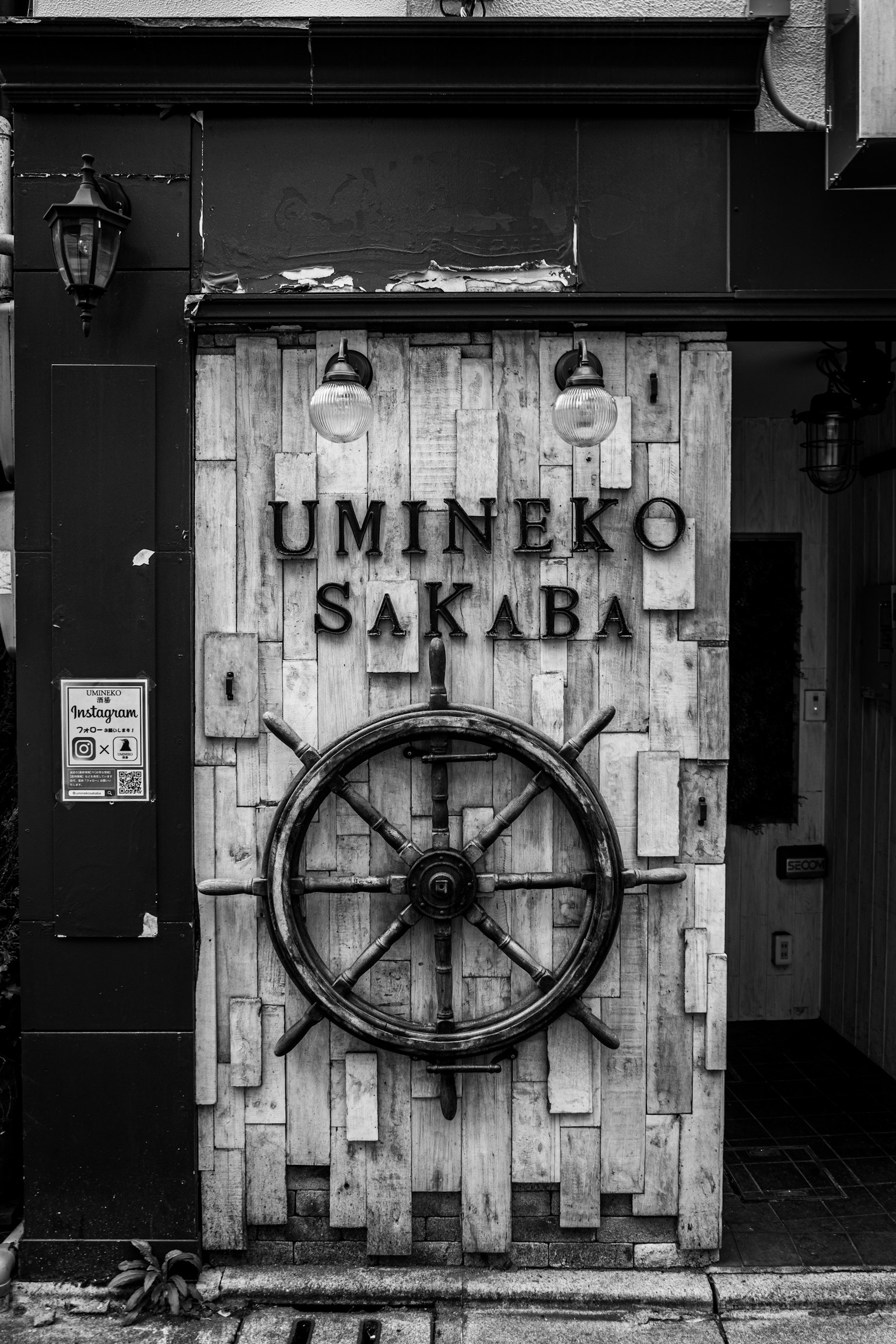 Wooden door of Umineko Sakaba featuring a decorative ship's wheel