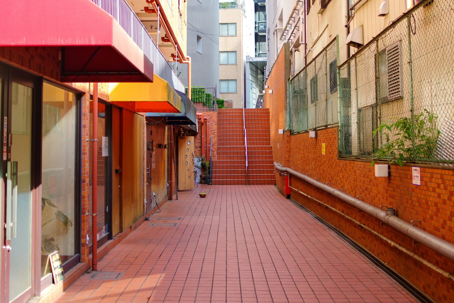 Urban street scene with red tiled walkway and stairs