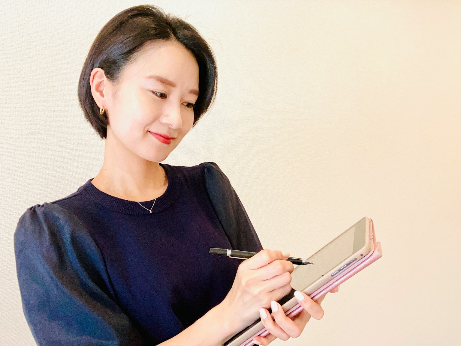 Người phụ nữ đang ghi chú trên máy tính bảng