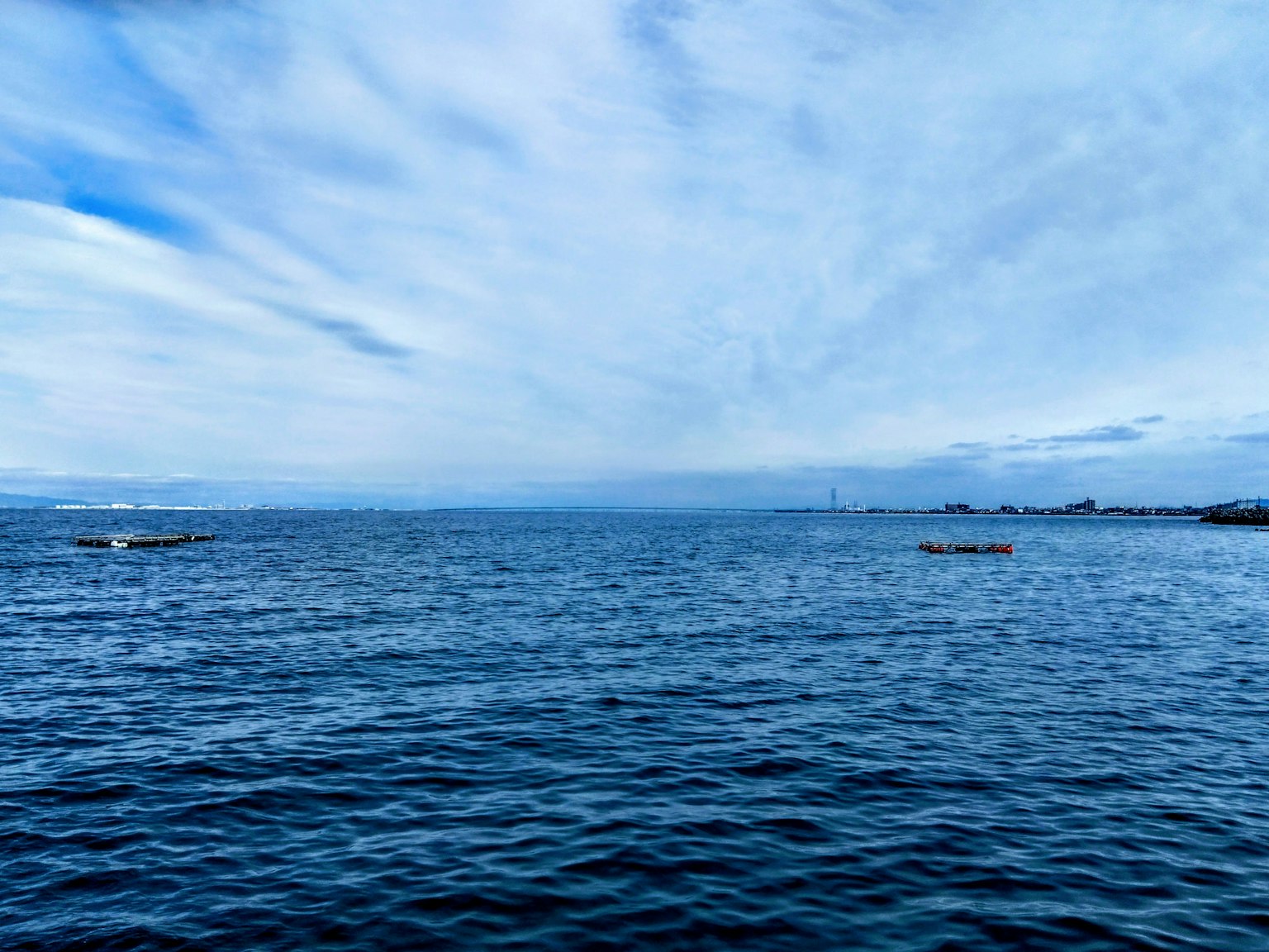 Ruhige Meereslandschaft und blauer Himmel mit mehreren Booten, die auf dem Wasser treiben