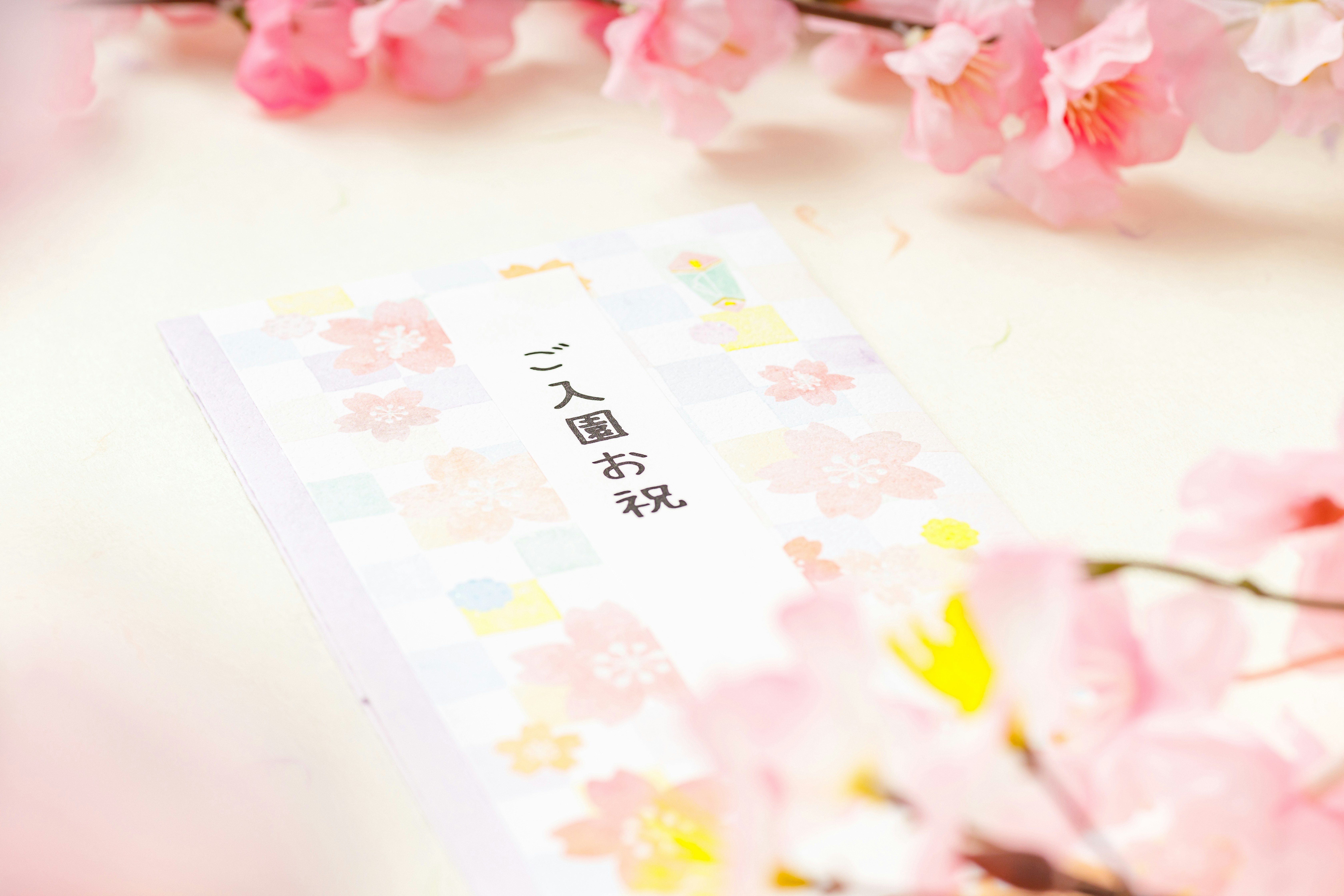 桜の花びらと入園祝いのメッセージカードが置かれたテーブル
