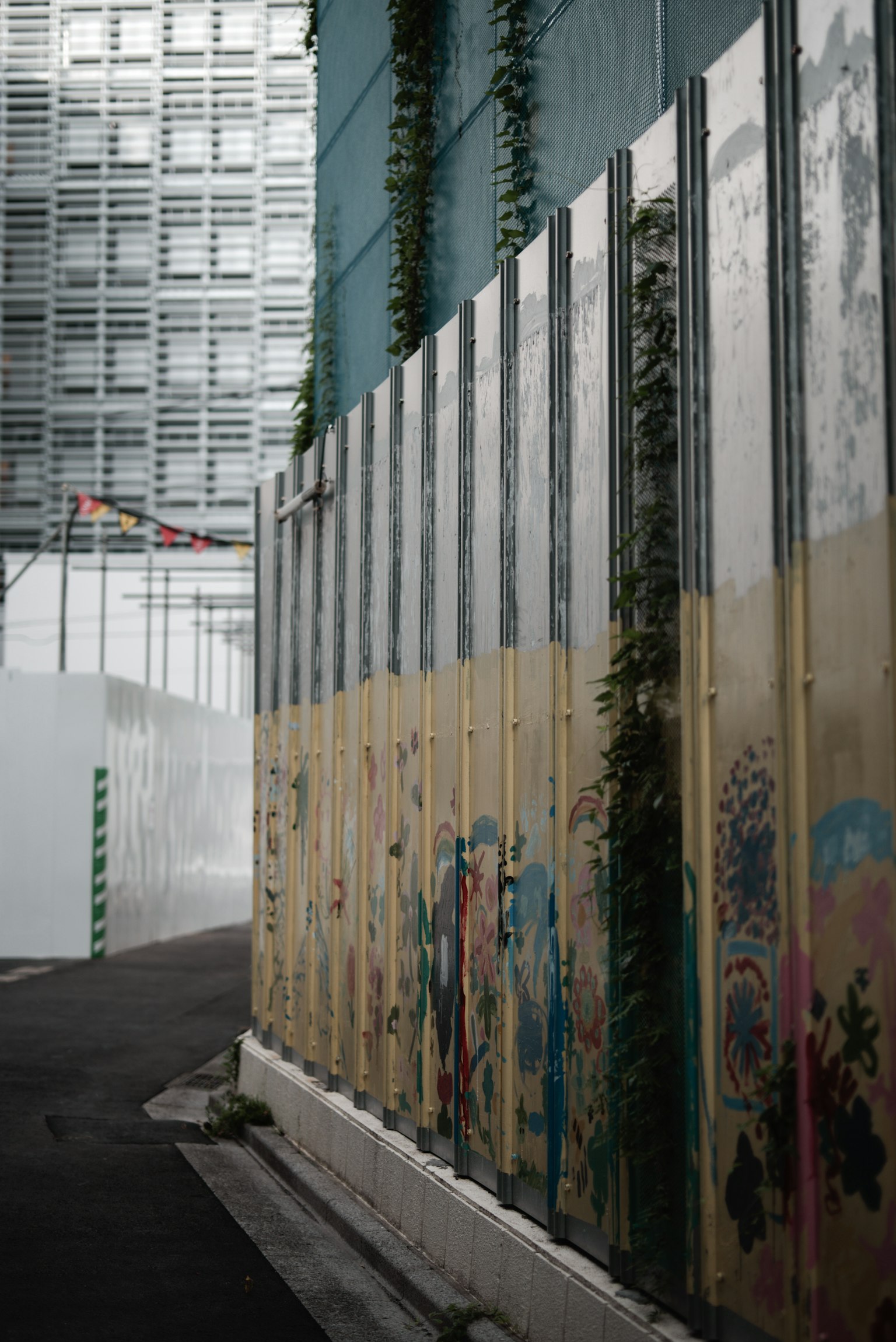 Grafiti colorido en una pared de construcción con plantas verdes entrelazadas