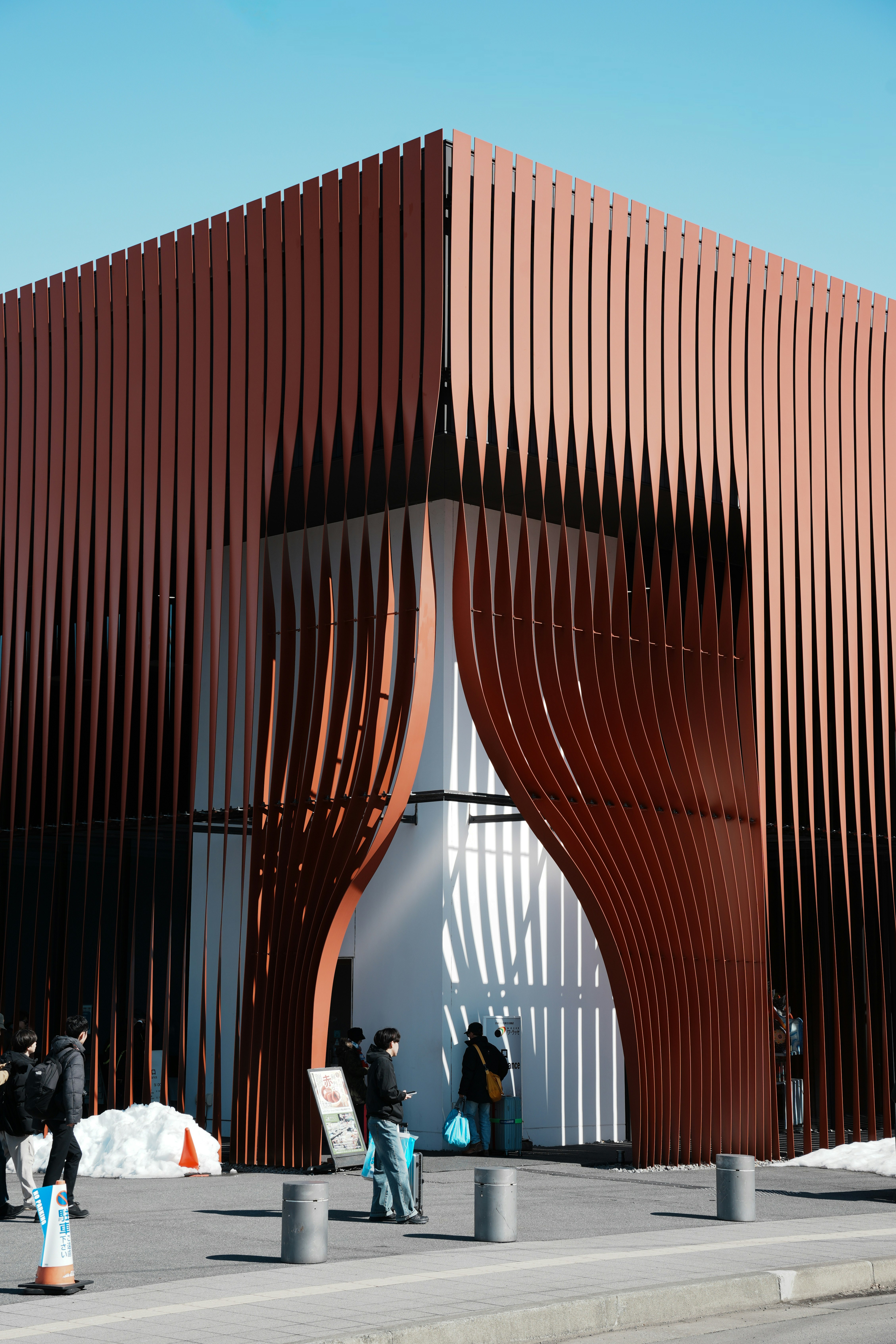 赤い格子の建物のアーチ状の入口前の広場