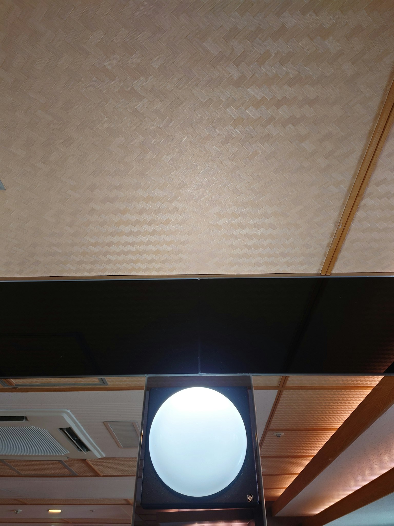 Image of an indoor ceiling design featuring a round light fixture