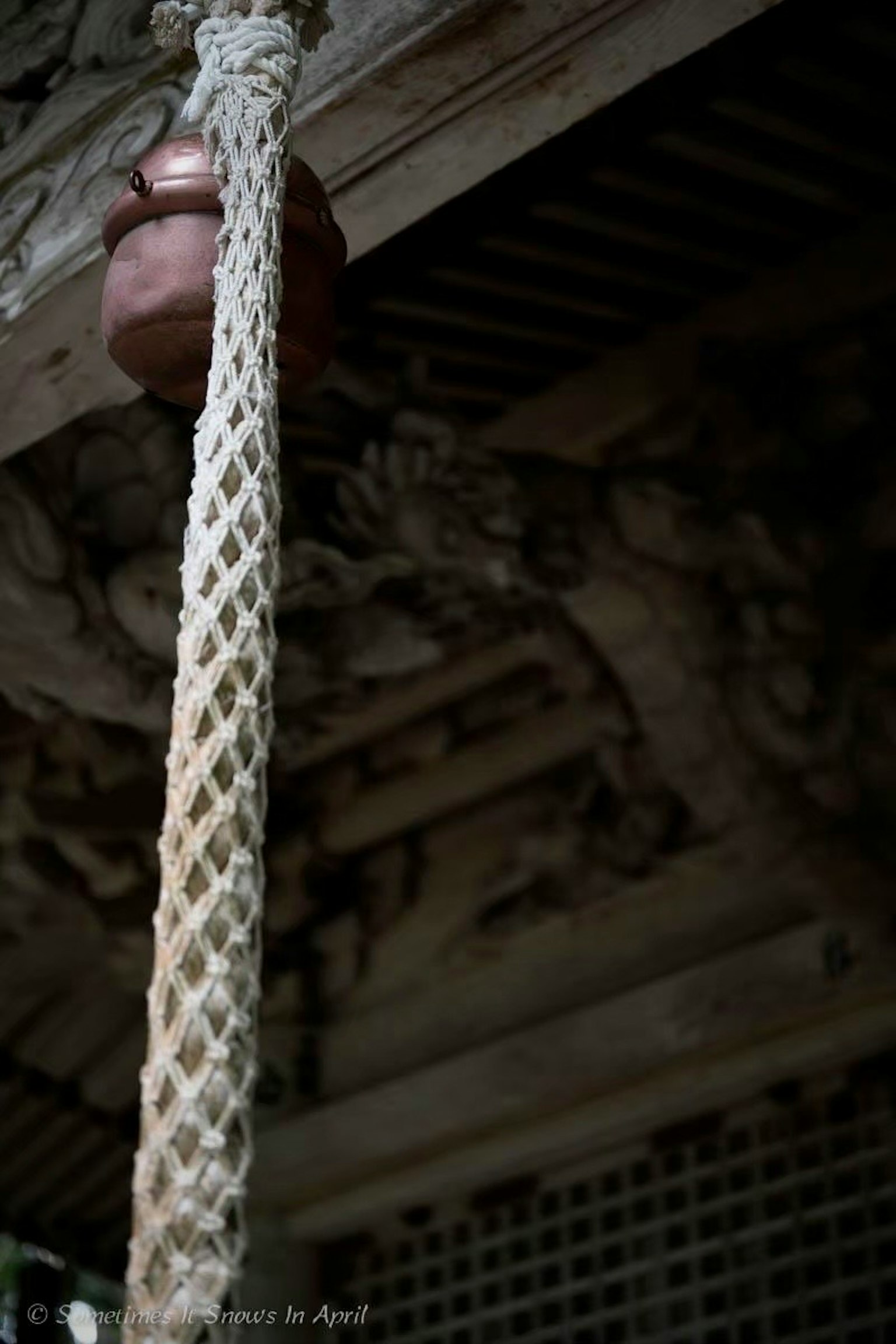 Interior of an old building featuring a ceramic pot suspended by a rope