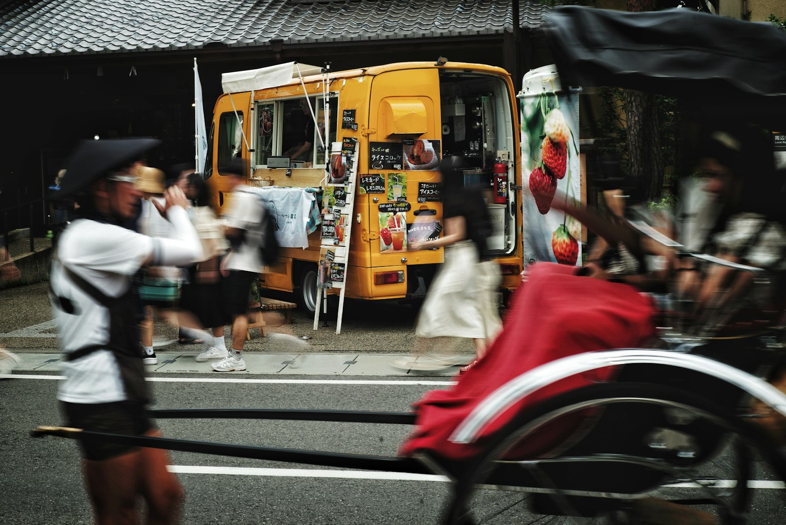 Sebuah truk makanan kuning cerah dengan orang-orang yang berjalan di jalan yang ramai