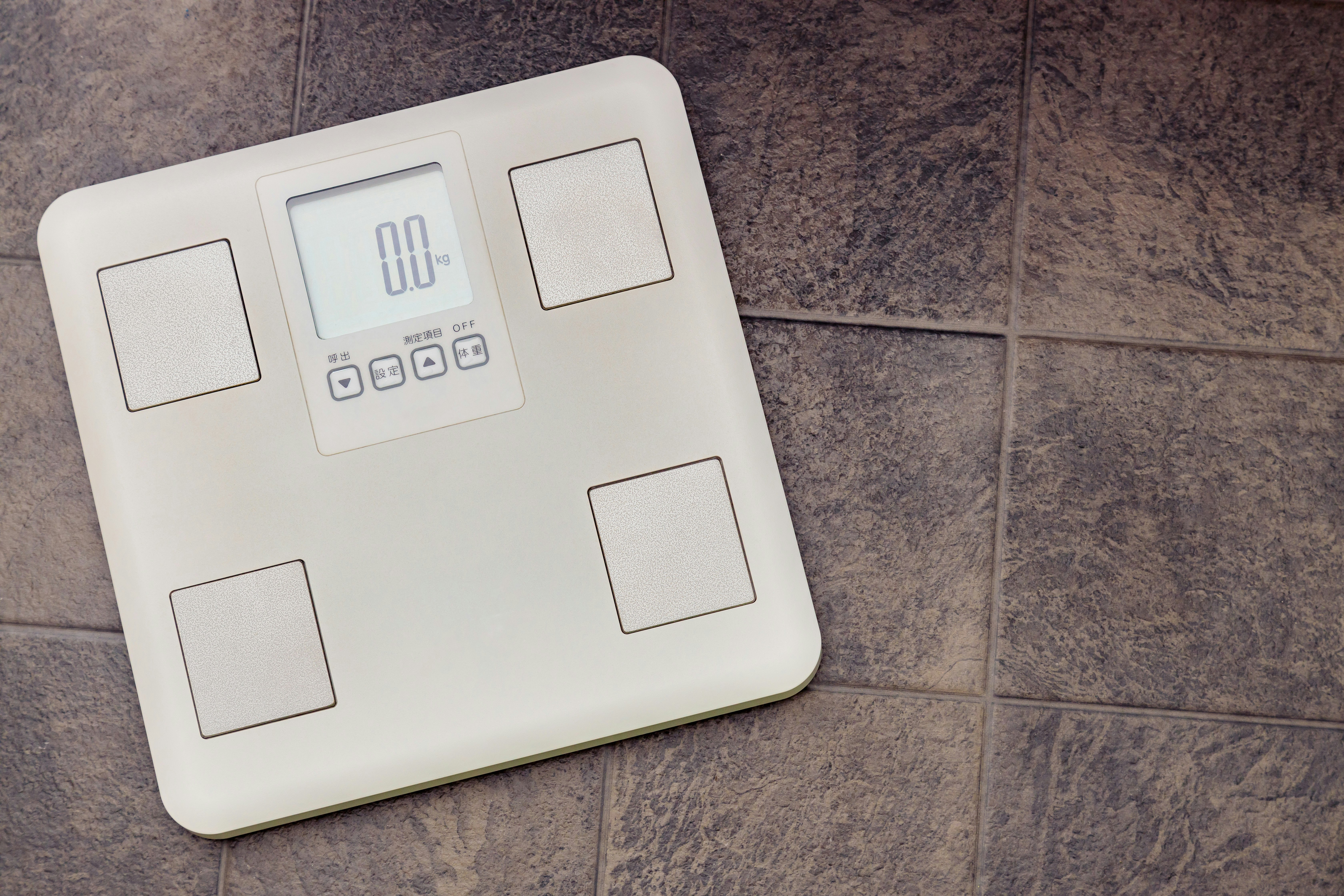 Digital bathroom scale on a tiled floor