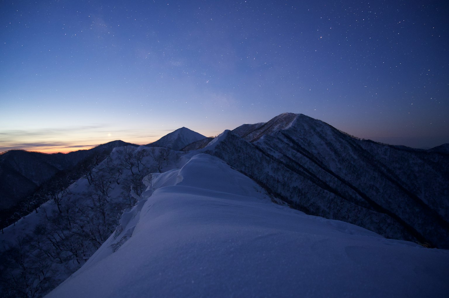 Schneebedeckte Berge unter einem Dämmerungshimmel