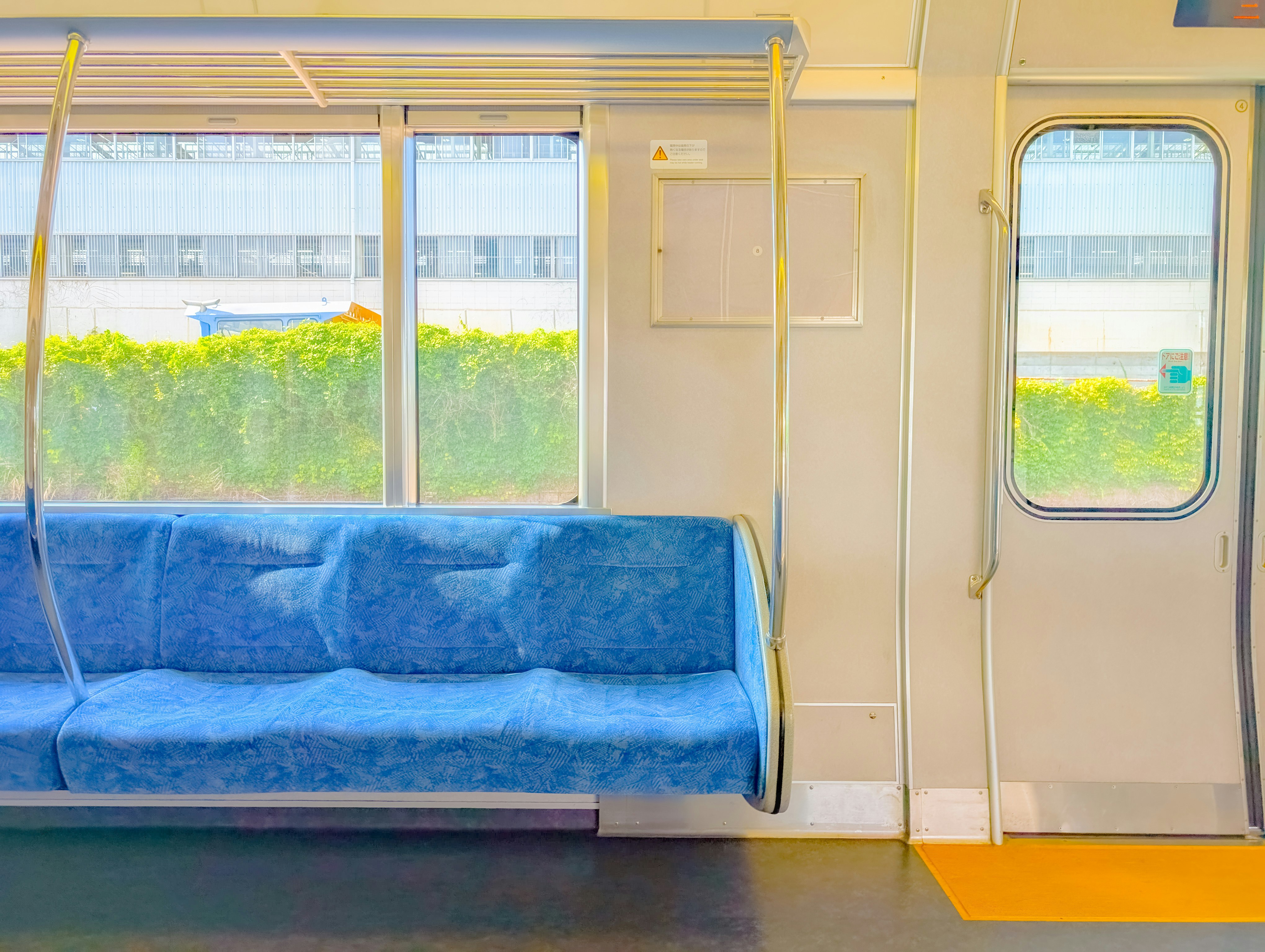 誰もいない電車の車内で窓辺の青い座席