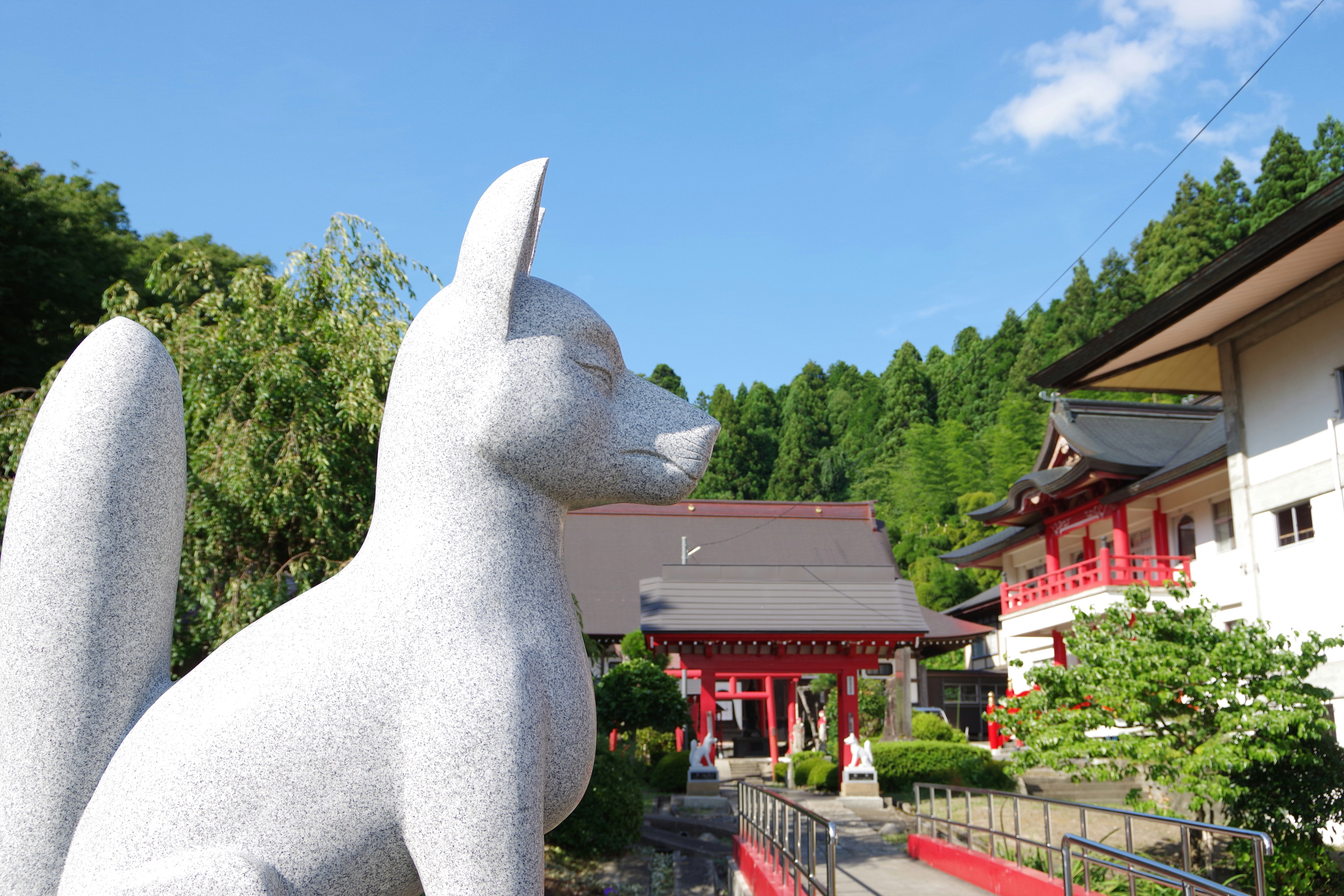 庭院步道上的獅子守護獸雕像與朱紅色神社建築