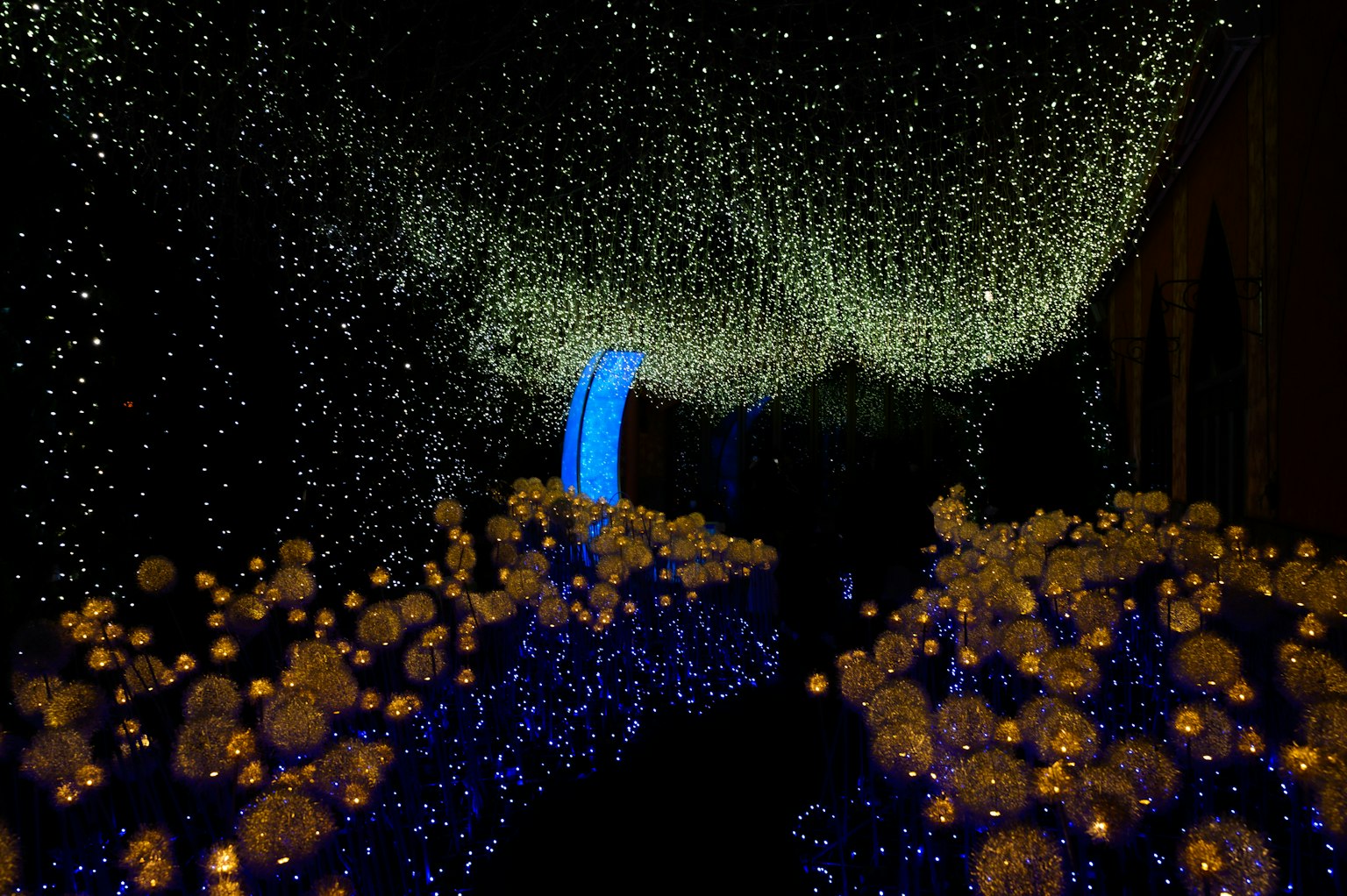 Una scena magica con un arco di luce blu e luci sferiche dorate sparse