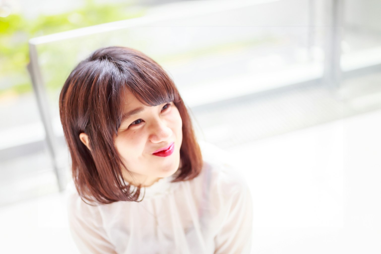 Retrato de una mujer sonriendo en un entorno brillante