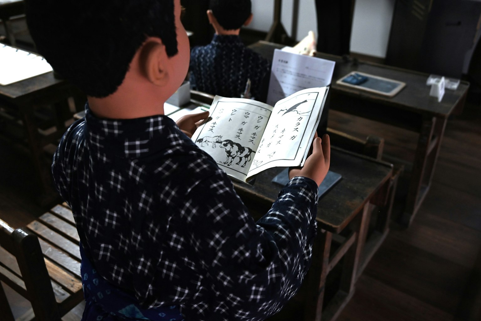 Garçon lisant un livre dans une salle de classe