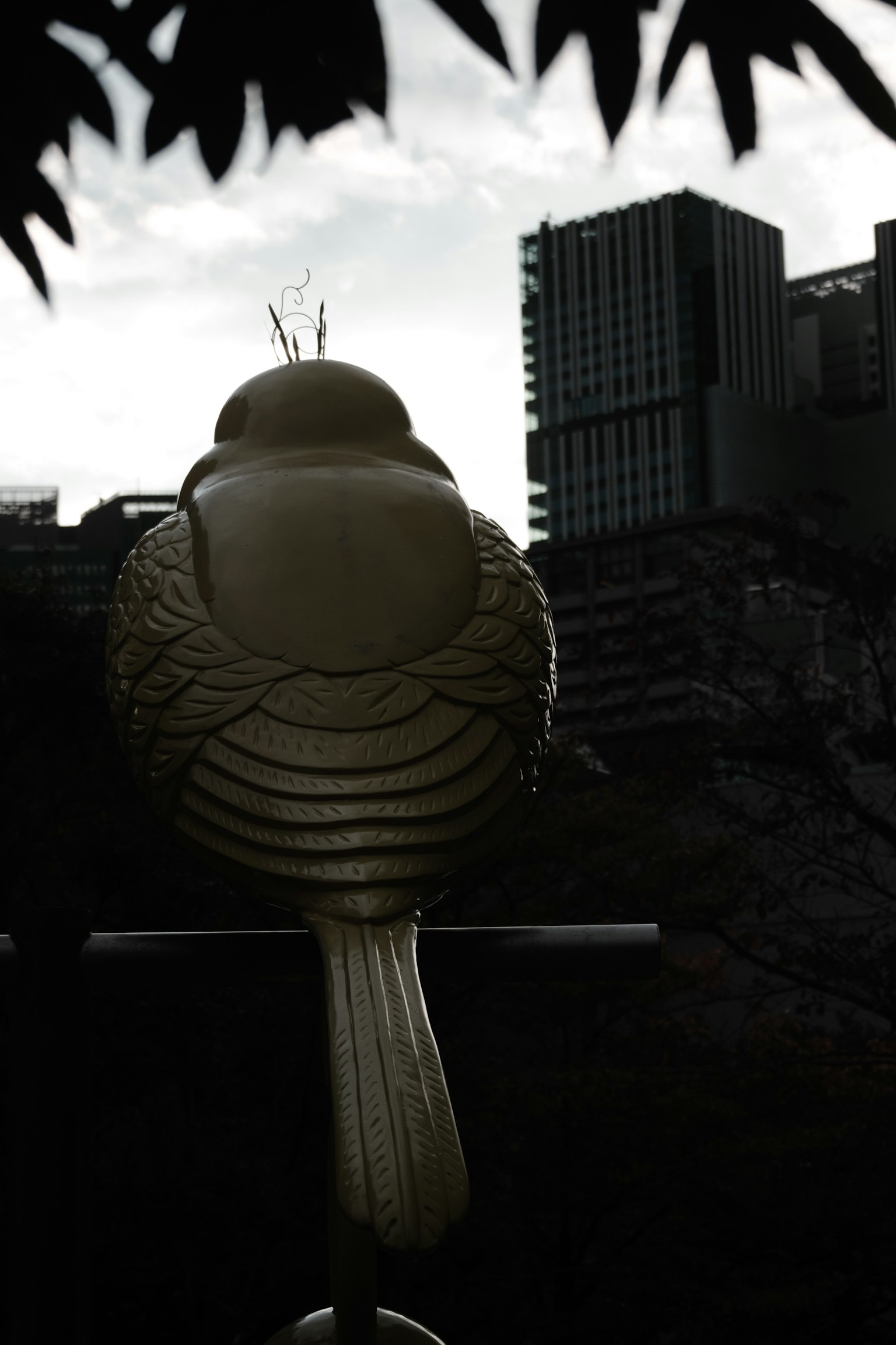 Silhouette einer Vogelskulptur mit modernen Gebäuden im Hintergrund