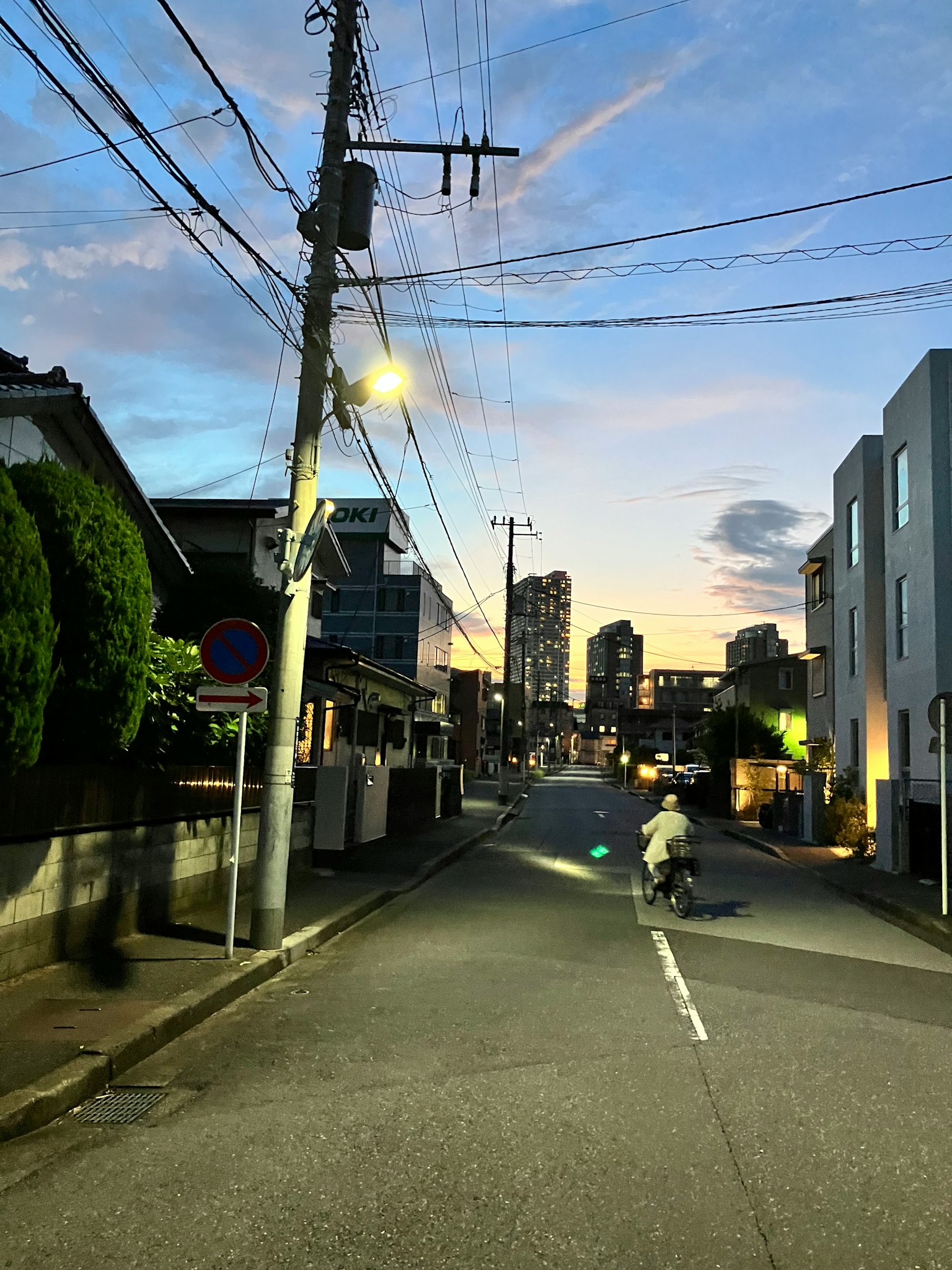 Une personne à vélo dans une rue de la ville au crépuscule