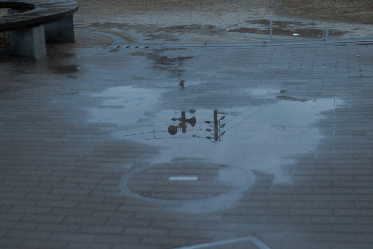 Reflection of a traffic light in a puddle on wet pavement