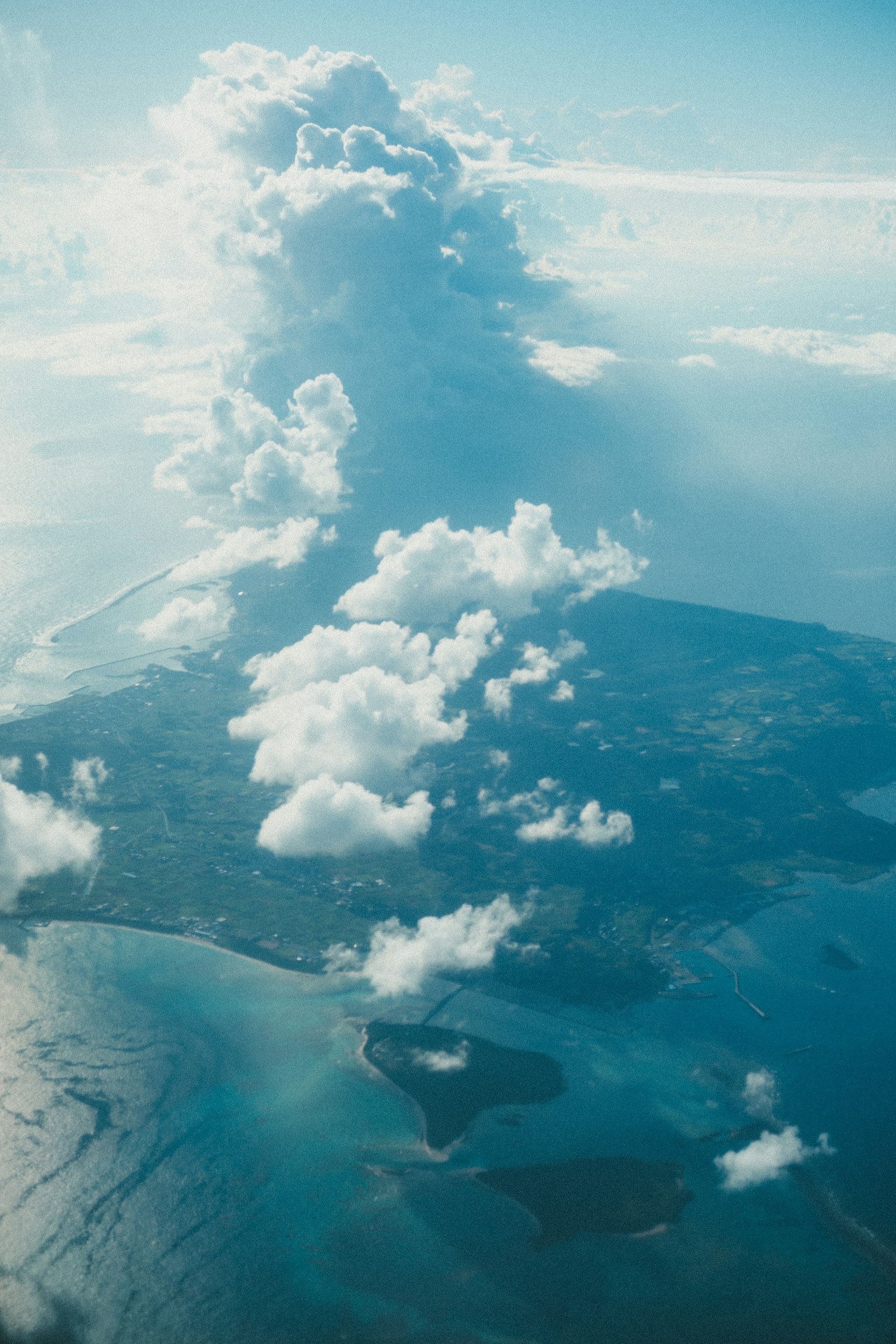 Vista aerea di un'isola circondata da acque blu e nuvole