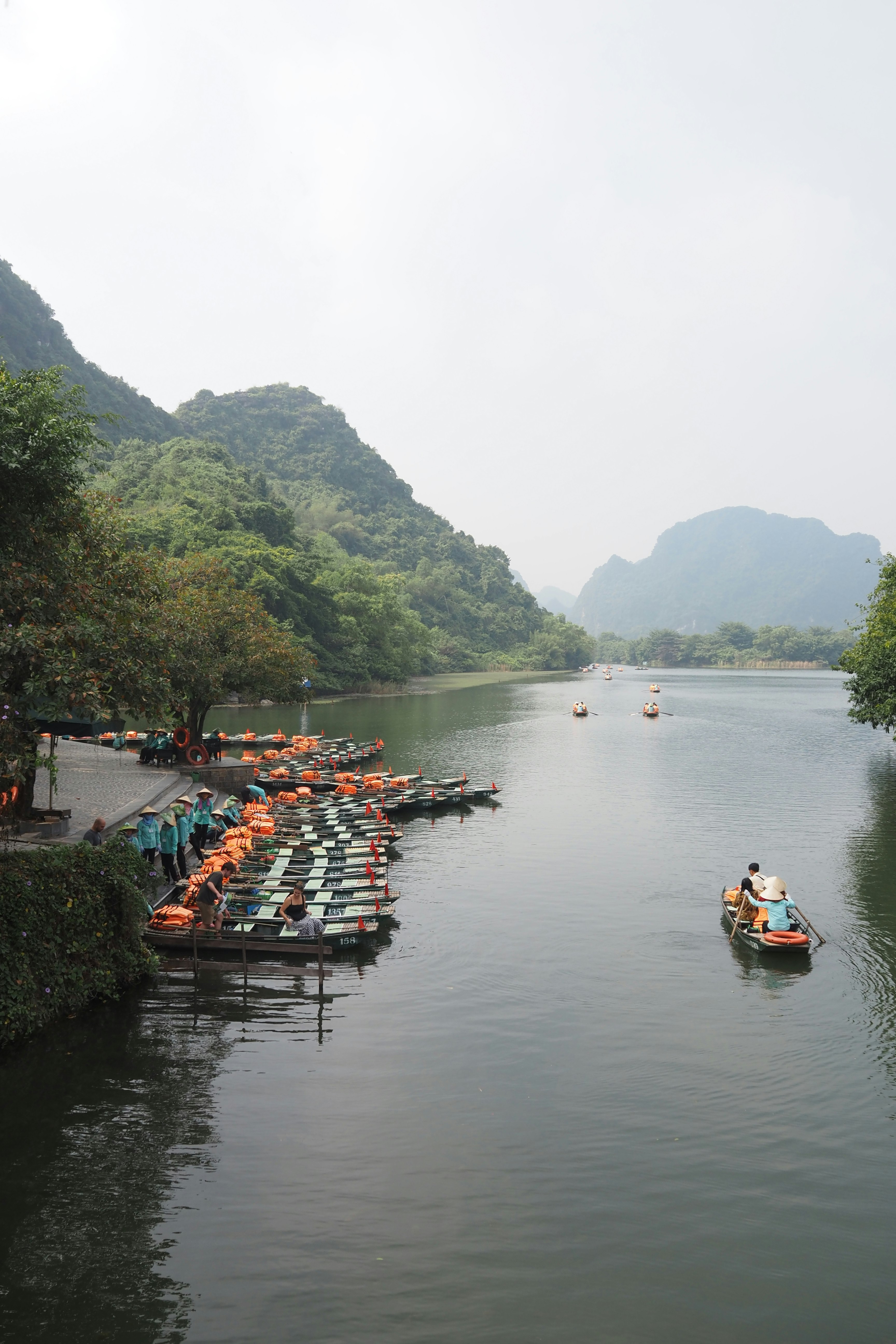 群山峽谷中的寧靜河流，成排的皮划艇與划艇