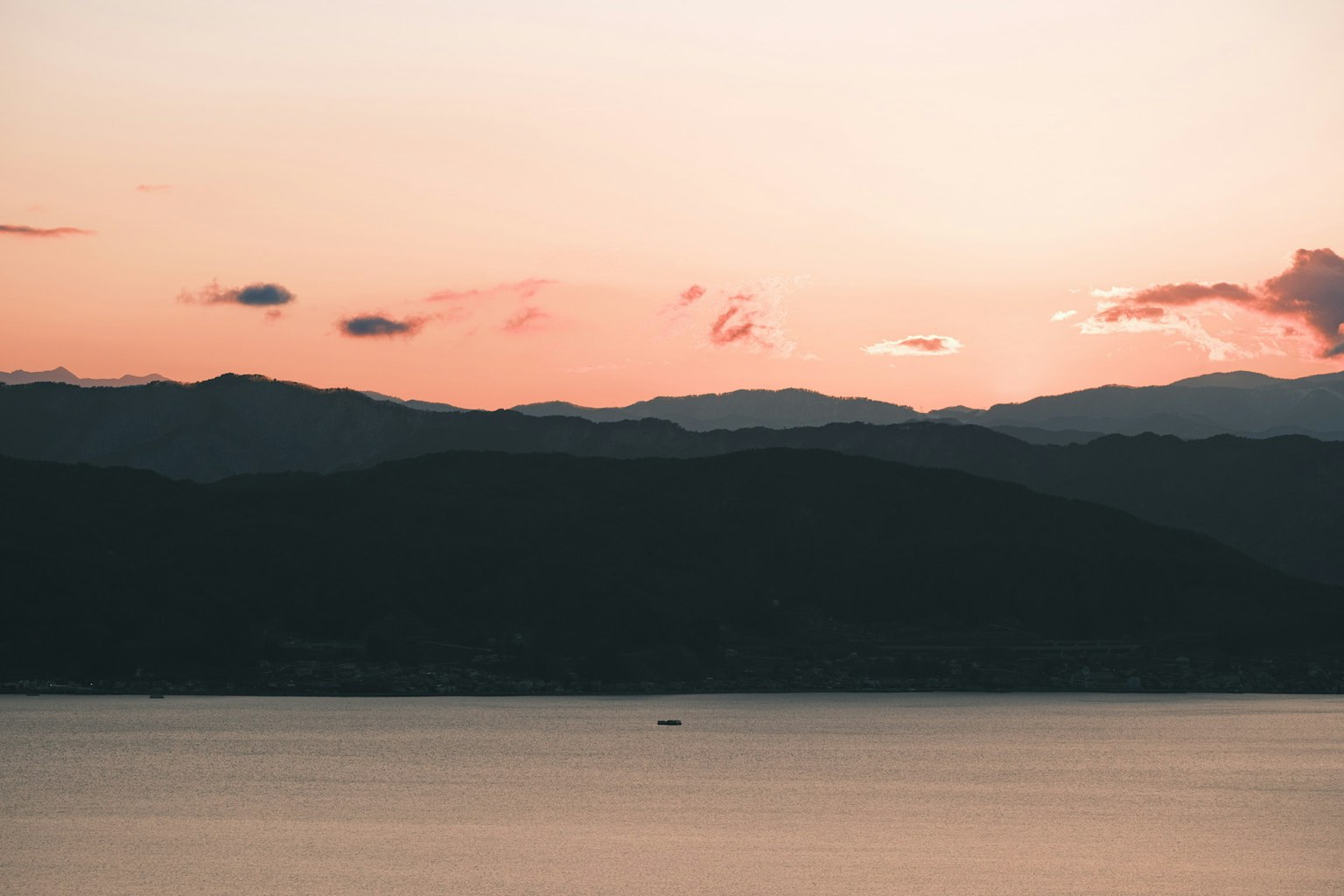 Vista panoramica delle montagne al tramonto con acqua calma